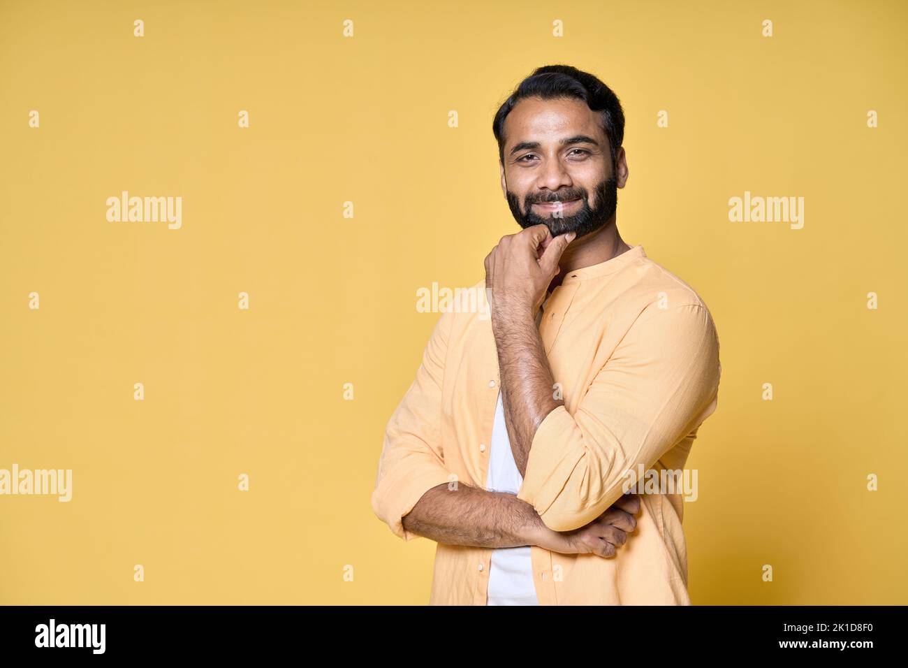 Confident bearded indian man standing isolated on yellow background. Stock Photo