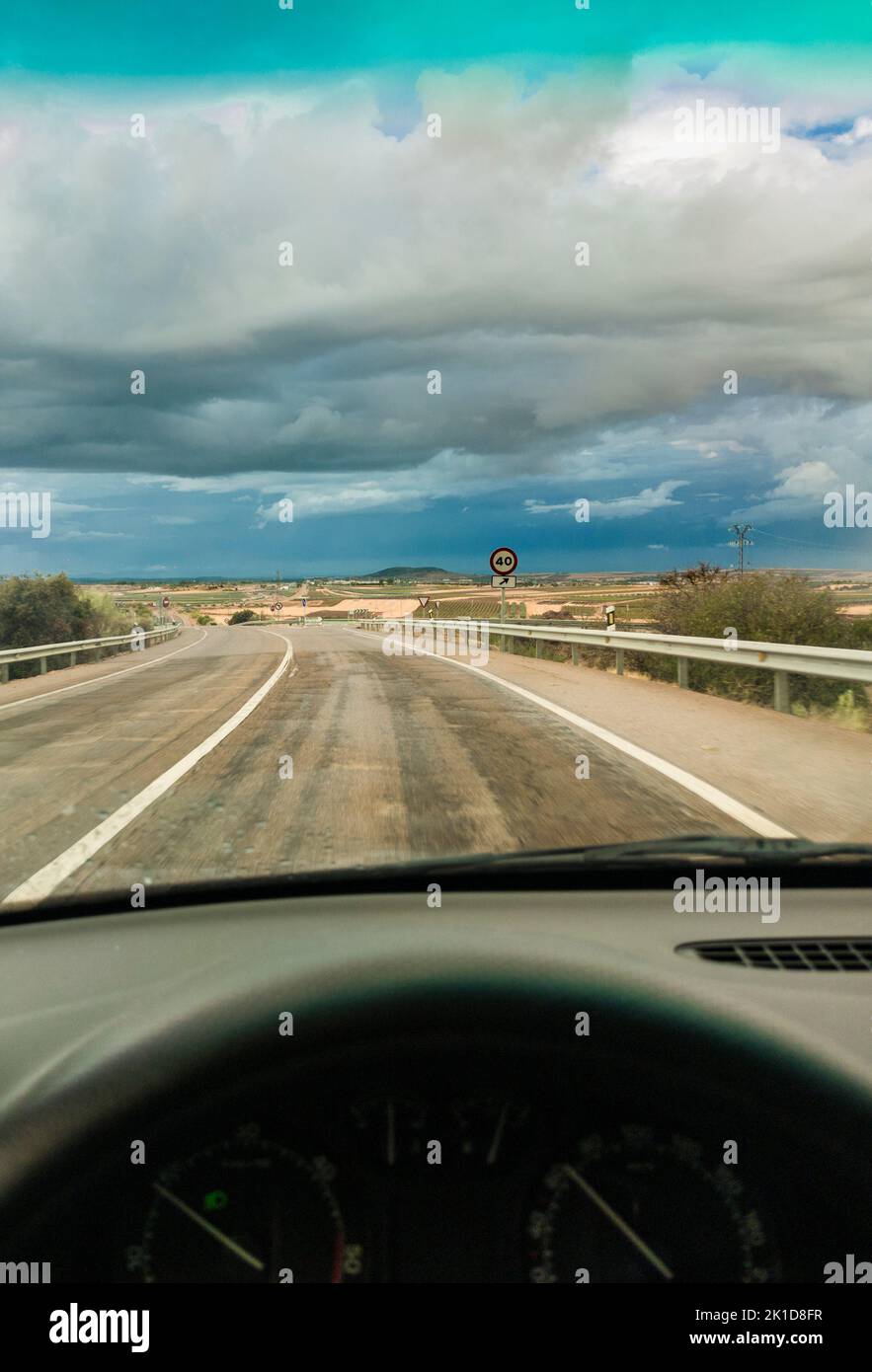 Driving under sunset stormy sky. View from the inside of the car Stock Photo