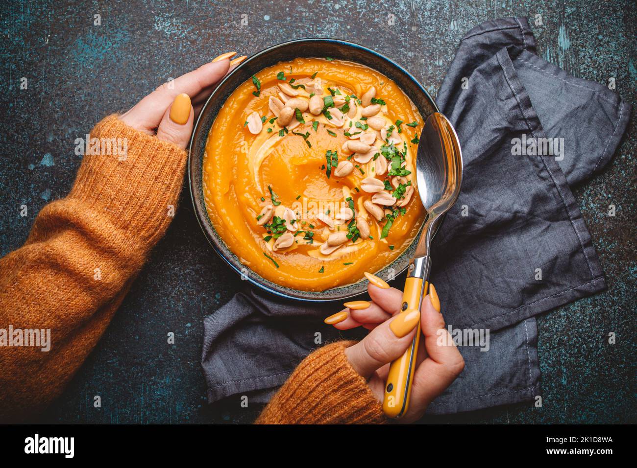 Female hands with bowl of pumpkin soup Stock Photo