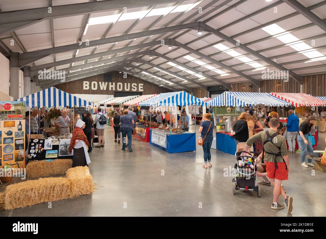 East Neuk, UK - August 14, 2022: Shoppers visit market stalls inside a barn at the rural country Bowhouse Farmer's Market at East Neuk in Fife, Scotla Stock Photo