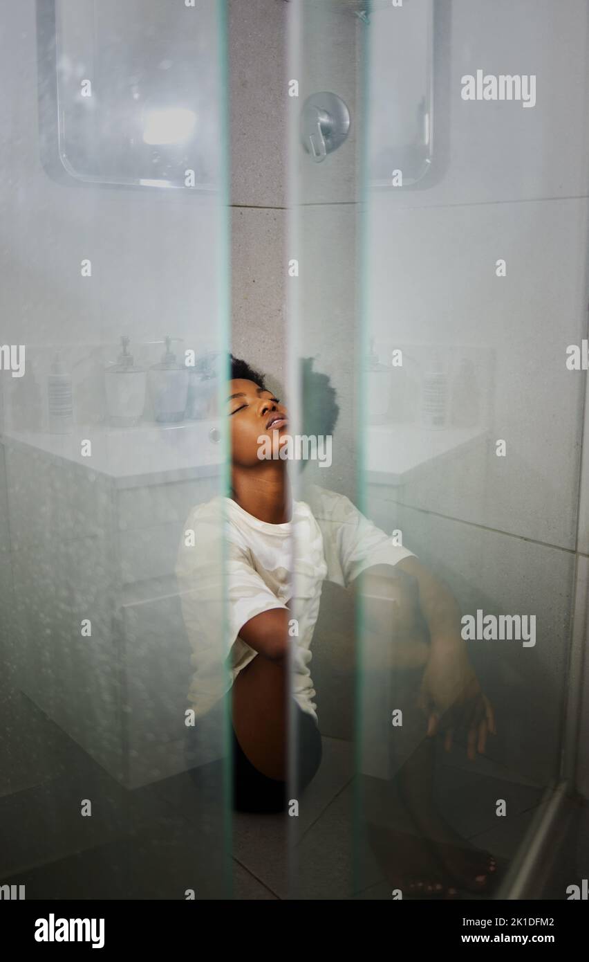 Mental health, anxiety and depression by sad woman sitting on floor the of a shower, stress and