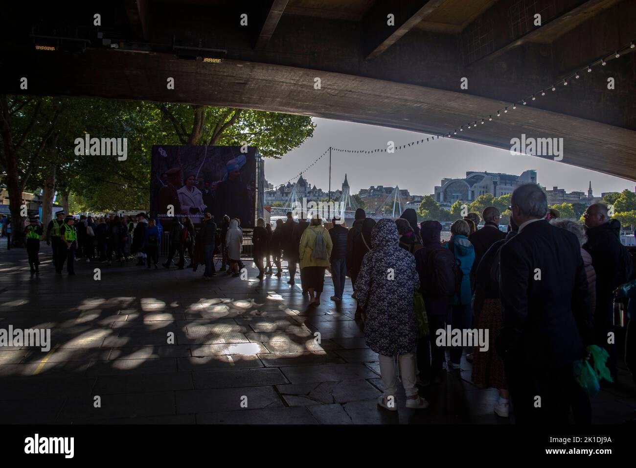 The Queue to see Queen Elizabeth lying in state passes under Waterloo bridge and the BFI screen on the Southbank on the River Thames London England UK Stock Photo