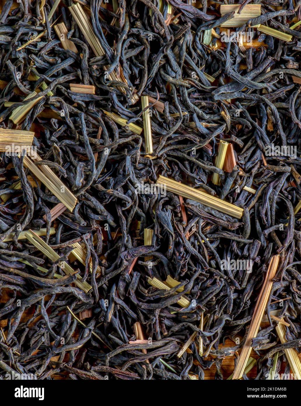 Background of fragrant black tea leaves with lemon grass. Dry texture of black tea. Stock Photo