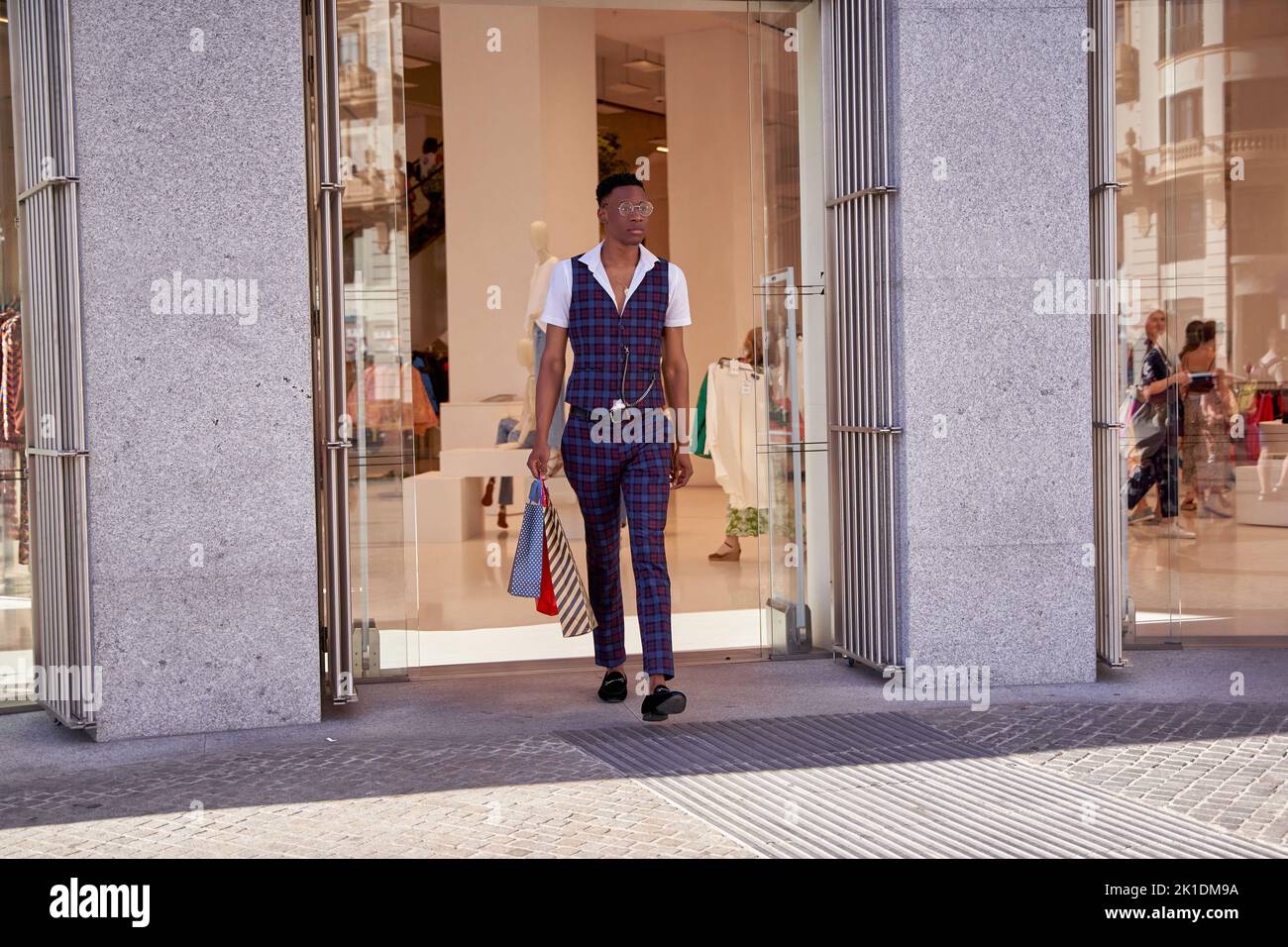 man leaving store with shopping bags Stock Photo