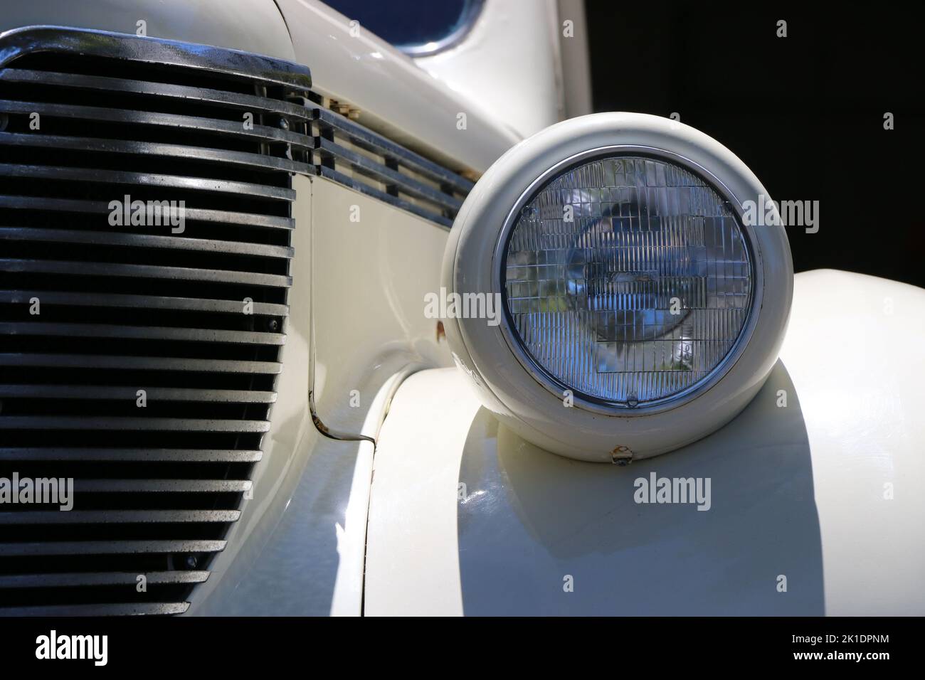 Monterey, CA, USA - 18 Aug 2022: Macro image of headlamp and front grille of a cream colored DeSoto sedan in pristine condition. Displayed during Clas Stock Photo