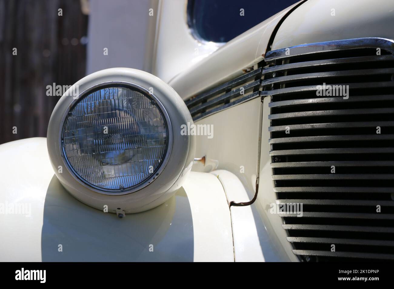 Monterey, CA, USA - 18 Aug 2022: Macro image of headlamp and front grille of a cream colored DeSoto sedan in pristine condition. Displayed during Clas Stock Photo