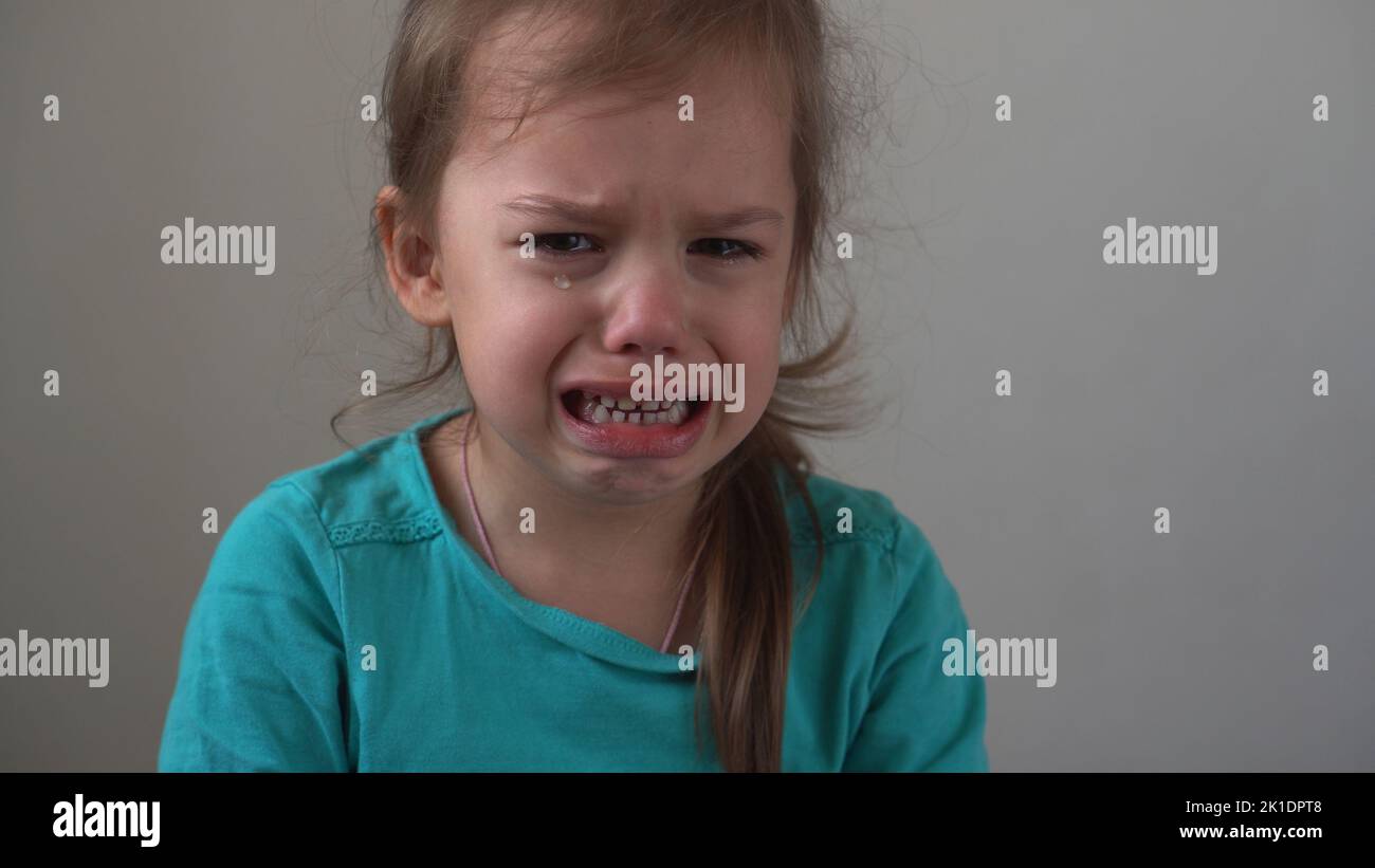 Portrait little girl sad upset child burst into tears cries sob looking