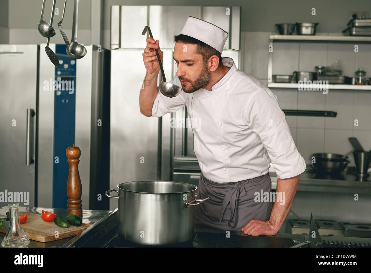 Chef tasting gourmet dish cooked in professional kitchen of restaurant Stock Photo