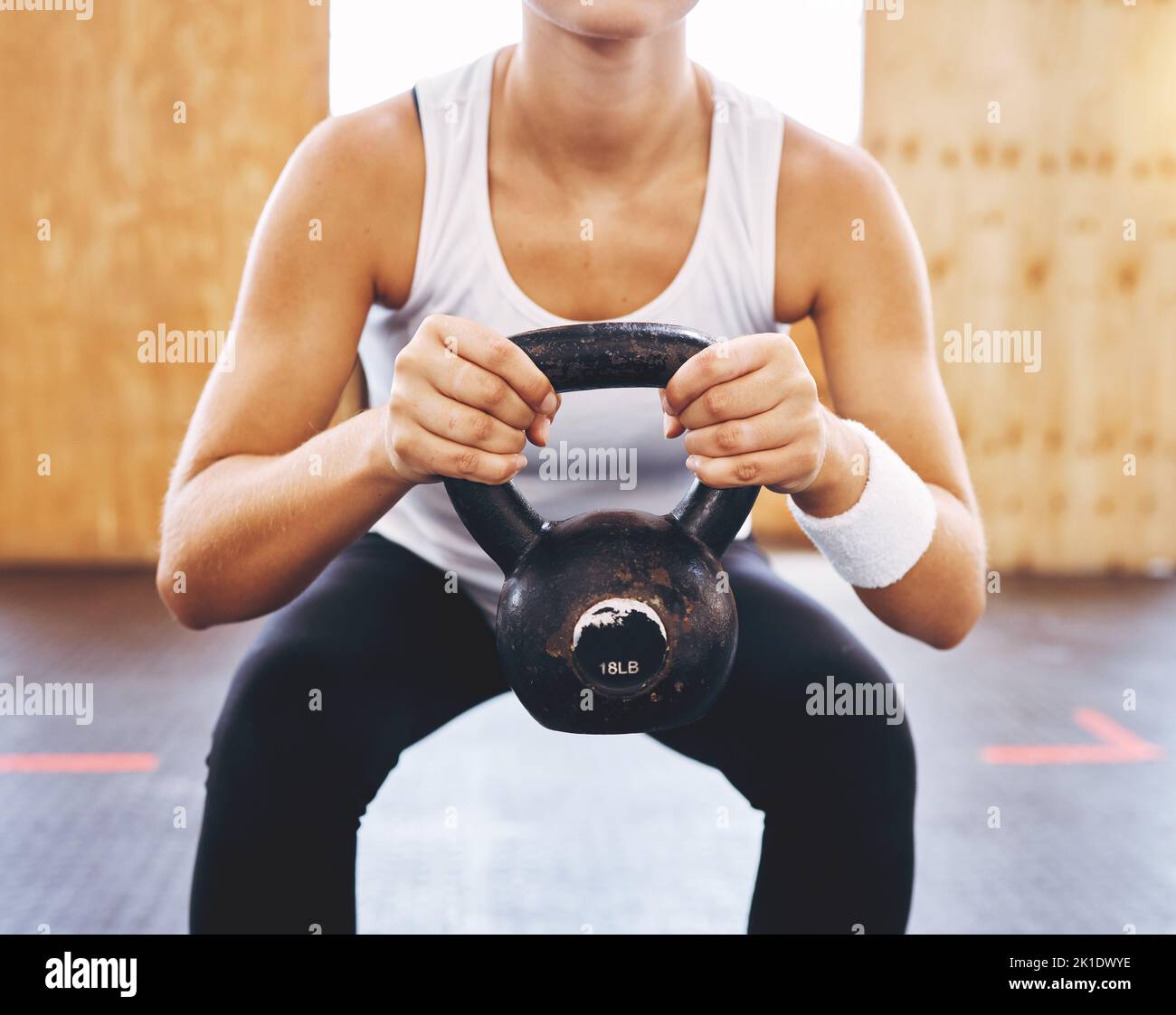 Health, energy and training with athlete woman weightlifting with kettlebell at fitness center or gym. Strong female doing power exercise and Stock Photo