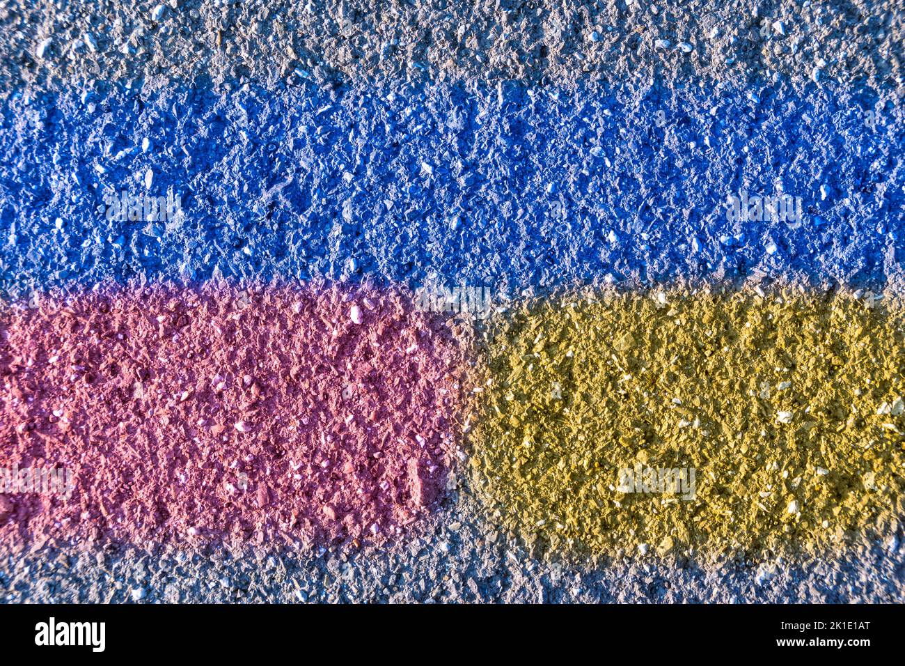 structure of an old road surface with a blue stripe and fragments of yellow and red Stock Photo