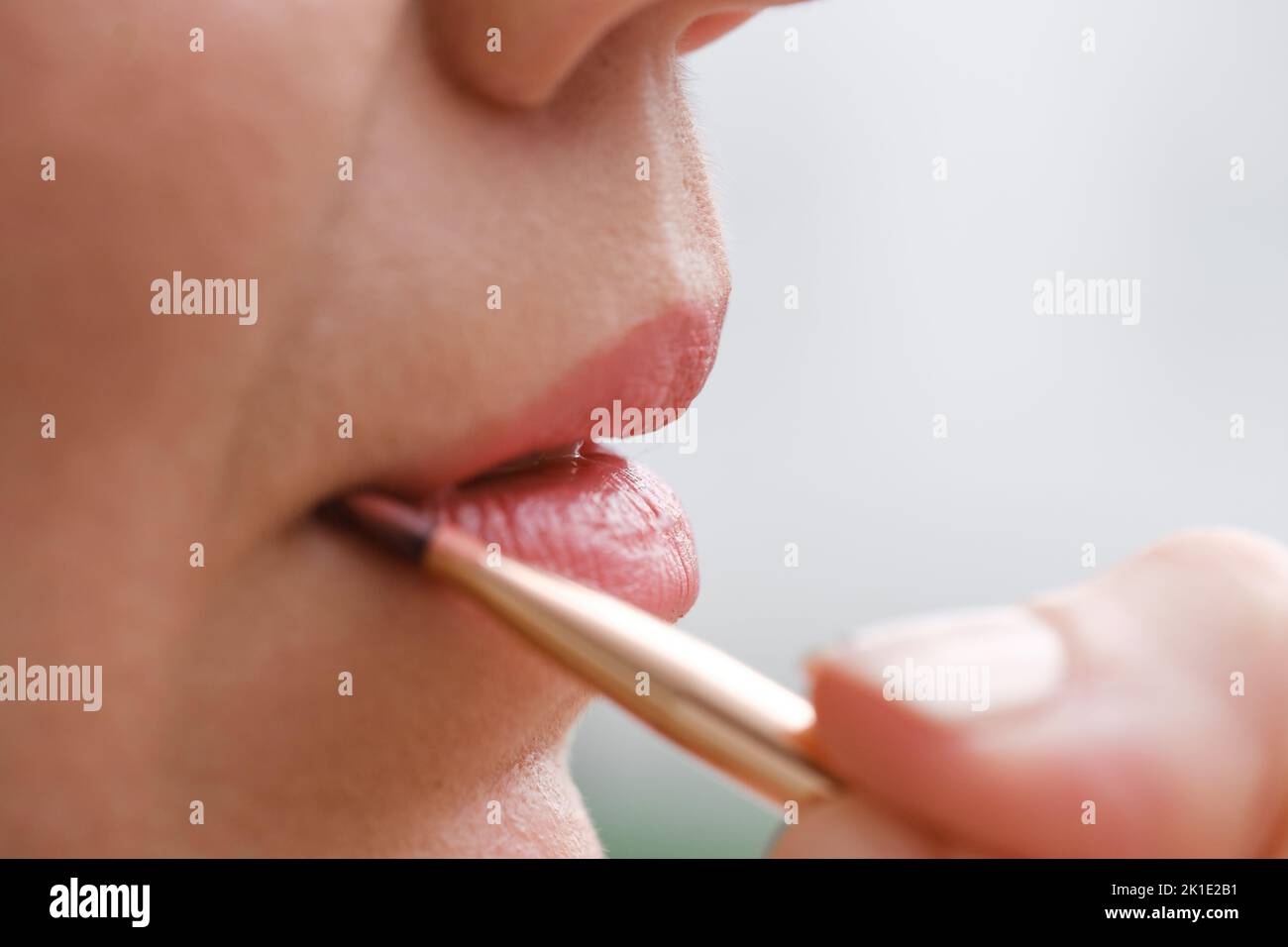 Applying makeup on face, closeup of lips with brush and contour pencil. Professional Make-up. Lipstick Copy space. Real people natural lips detail Stock Photo