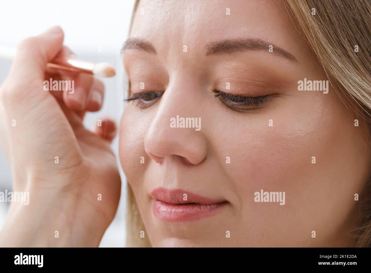 nude eye make-up close-up. woman applying eyeshadow powder. Processional look natural female Stock Photo