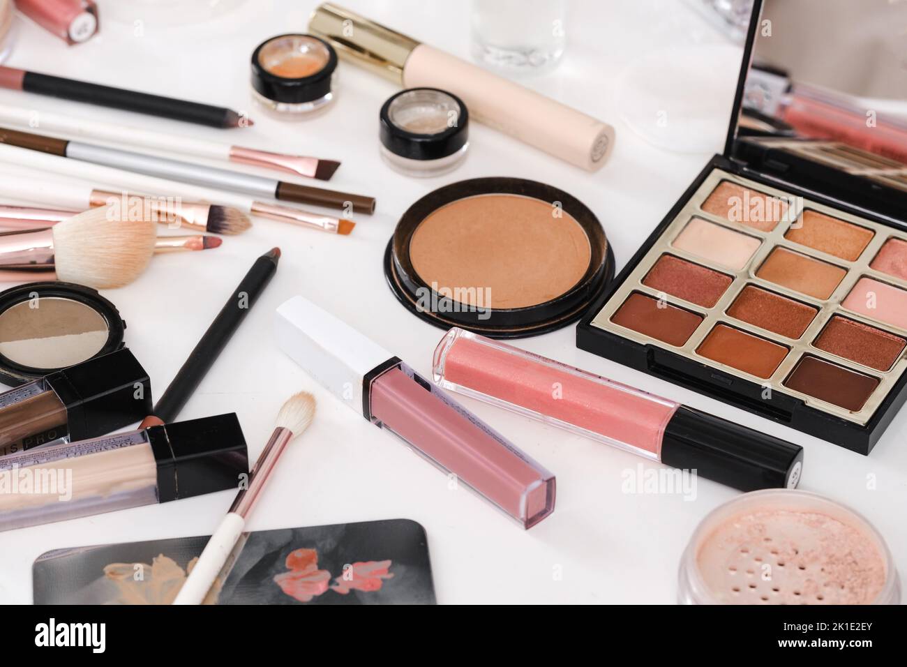 make-up tools and cosmetics on white table. Decorative cosmetics, brushes, eyes shadow, pencils with foundation on dressing table or beauty salon Stock Photo