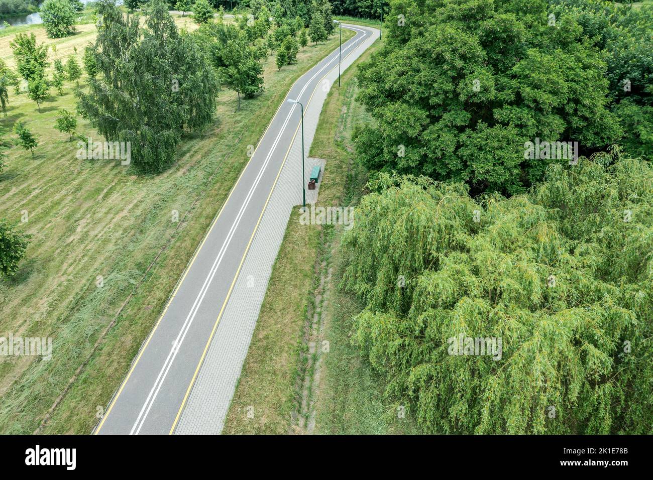 bike lane with footpath in summer park. landscape with green trees. aerial drone view. Stock Photo