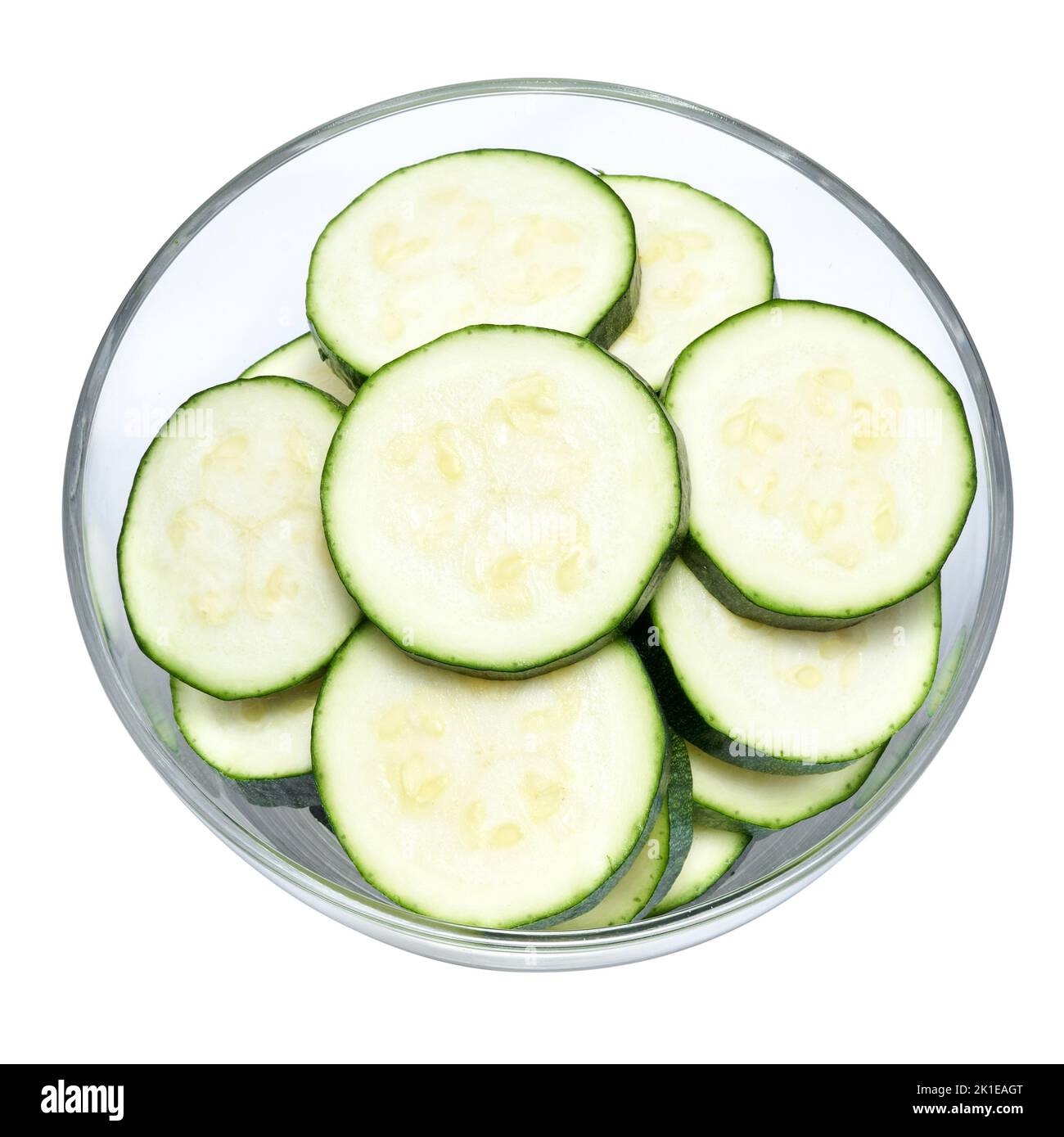 Sliced zucchini circles in glass bowl isolated on white background Stock Photo