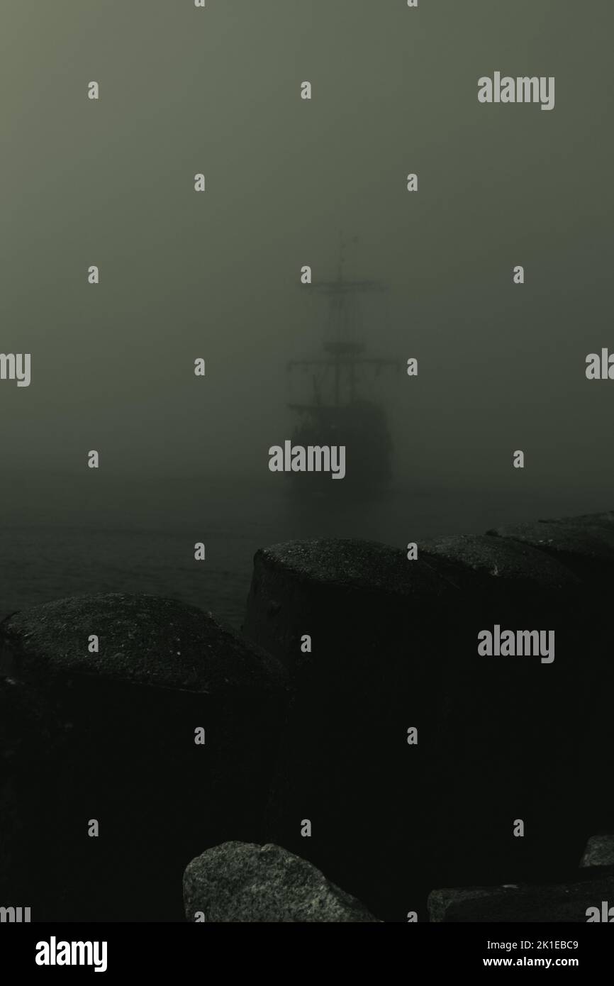 A vertical shot of pirate ship entering the port on a foggy day Stock ...