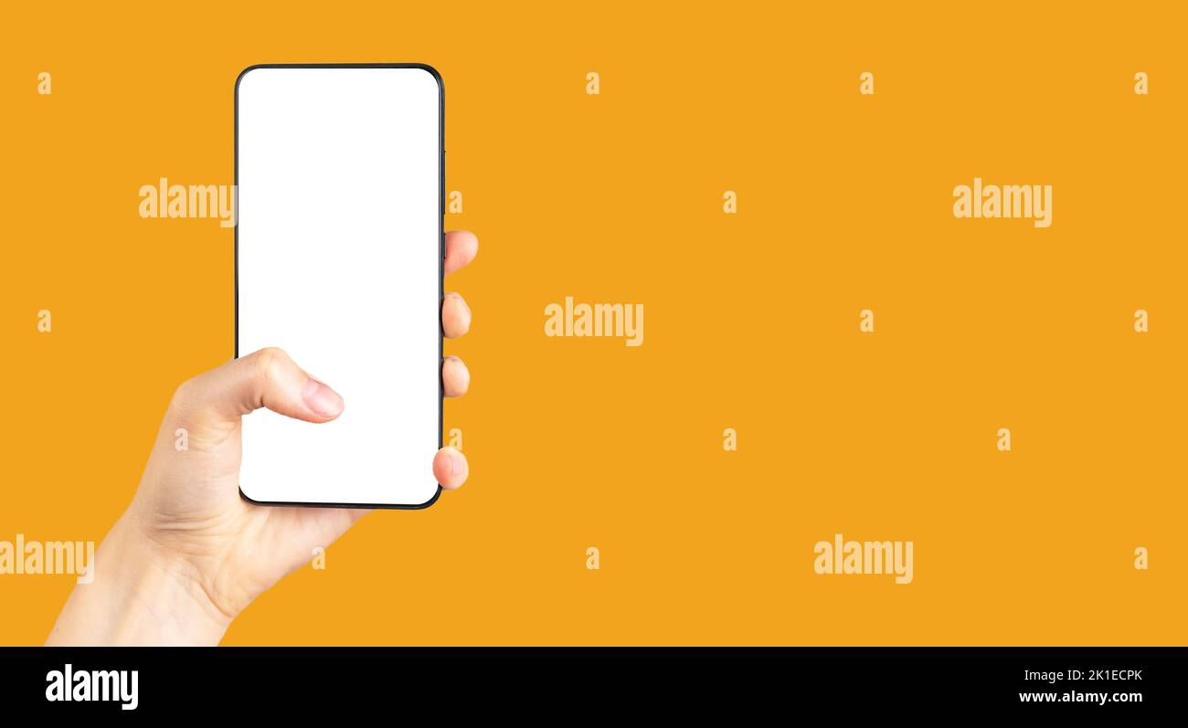 Banner with thumb tapping on phone mockup on orange background. Smartphone template with empty screen. Woman hand holding android. Copy space. High qu Stock Photo