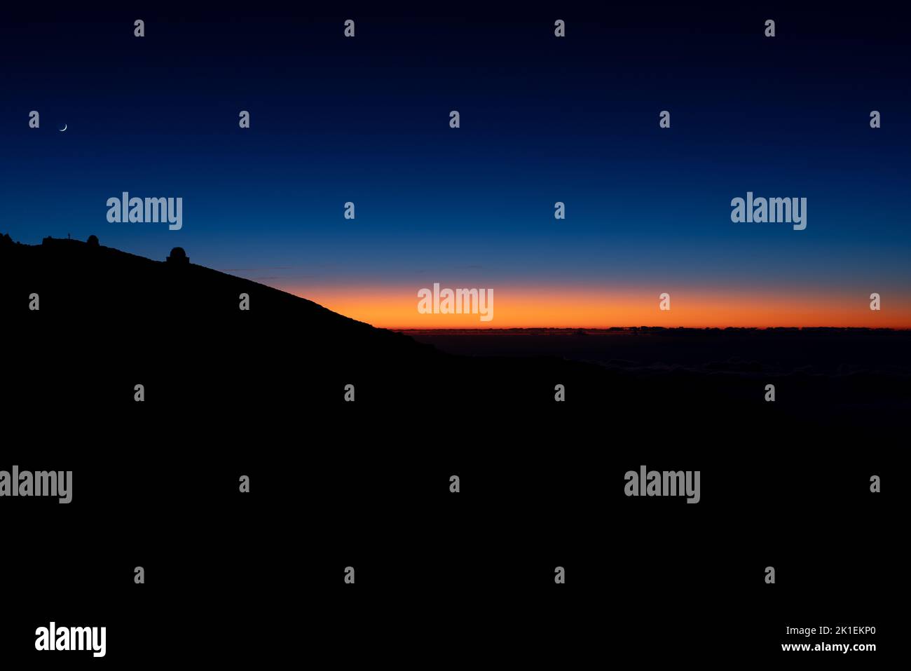 Rising moon and astronomical observatory over the mountain at sunset Stock Photo