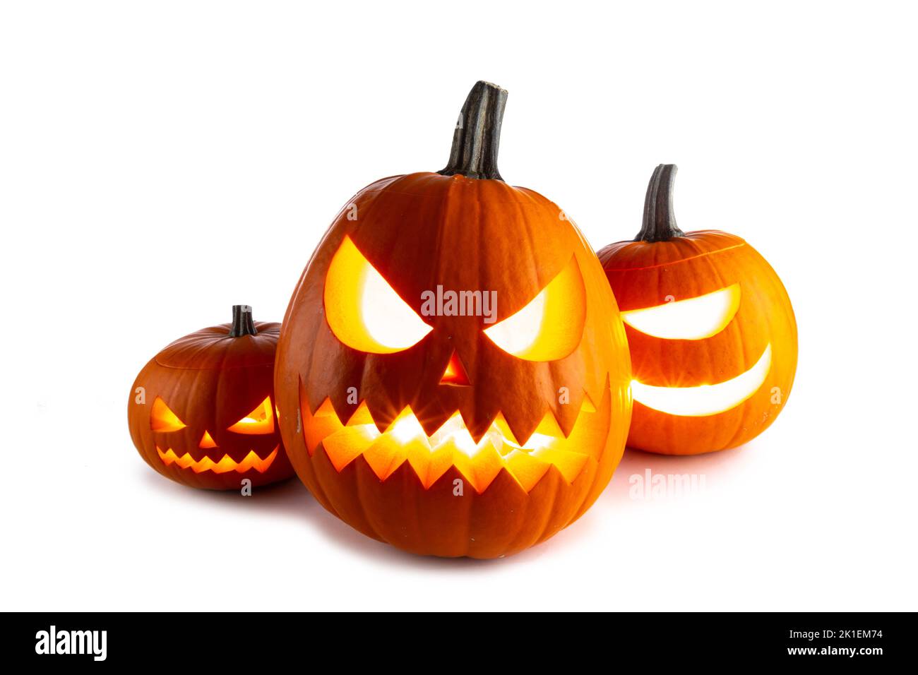 Three Halloween glowing funny lantern pumpkins isolated on white background Stock Photo