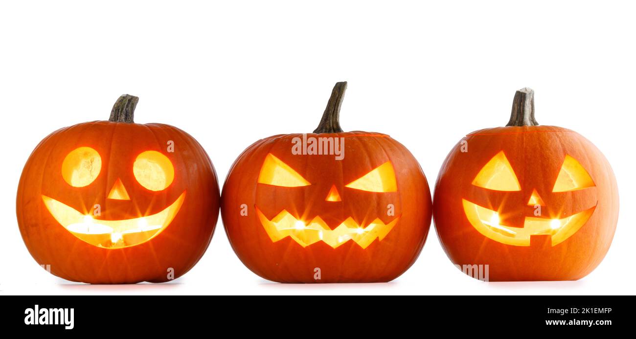 Three Halloween glowing lantern pumpkins in a row isolated on white background Stock Photo