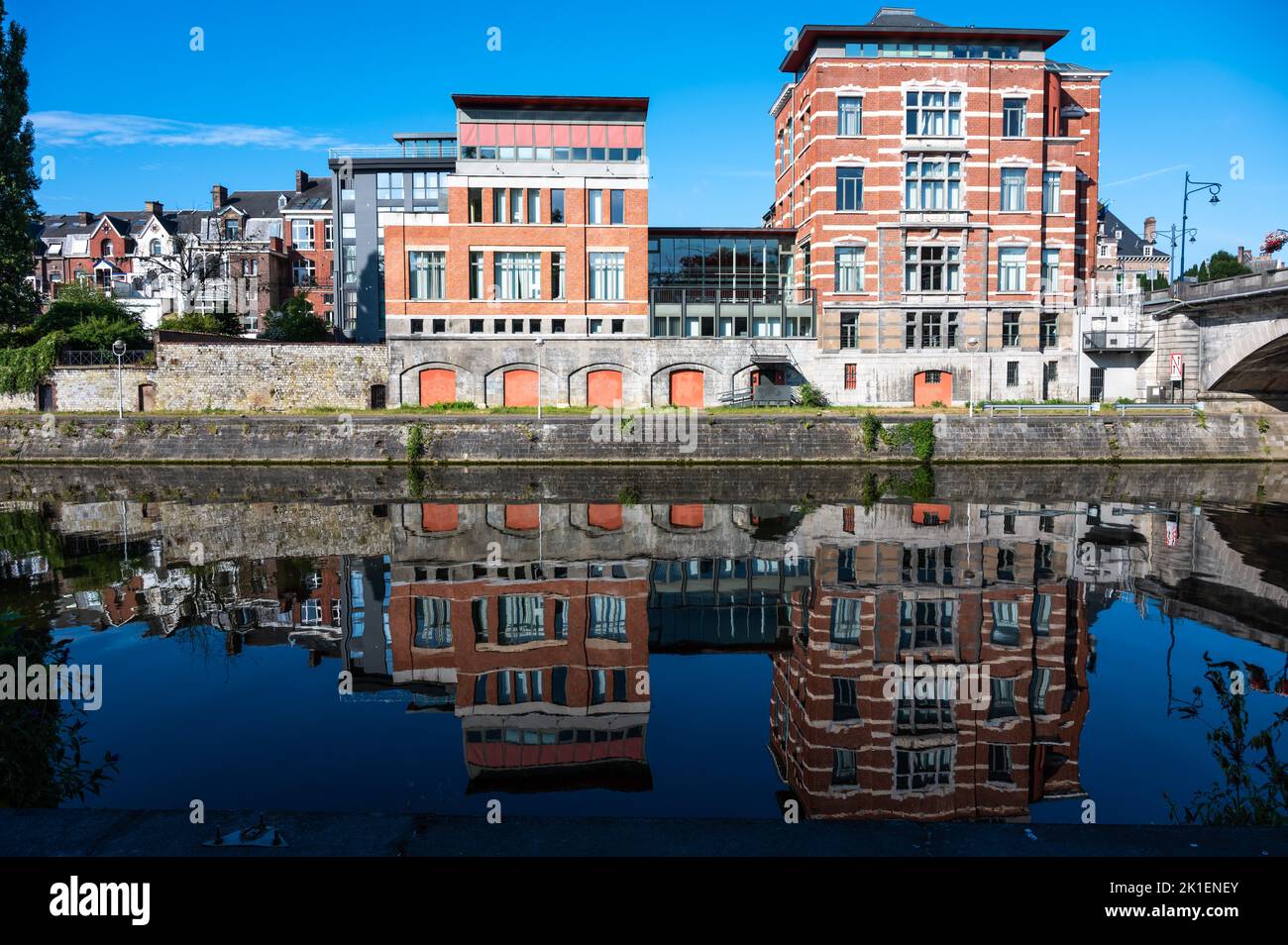 Namur, Wallon Region, Belgium, 07 28 2022 - Historical buildings reflecting in the blue water of the River Sambre Stock Photo