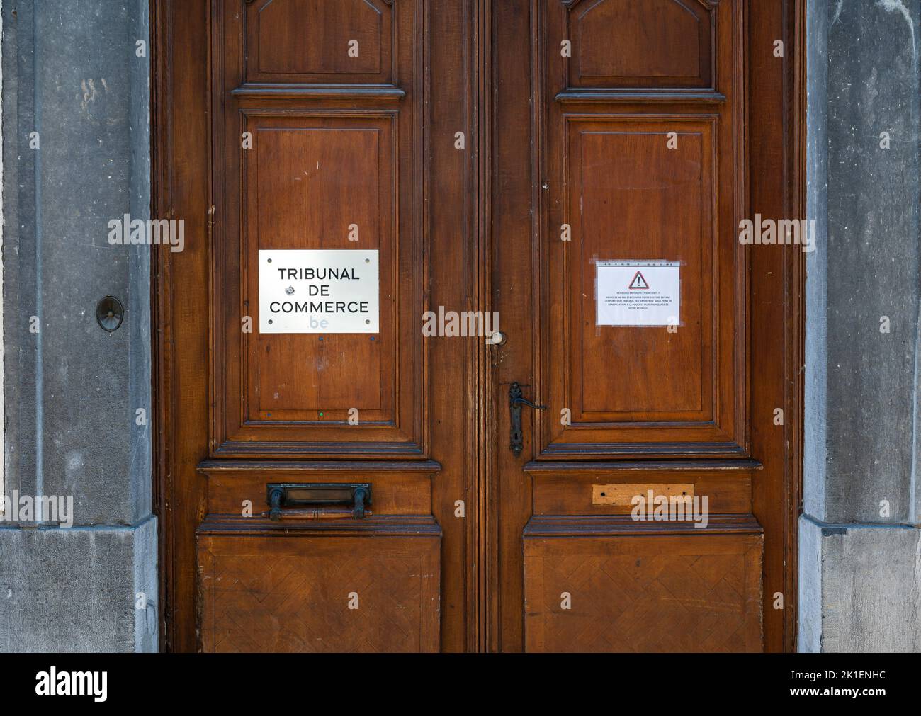 Namur, Wallon Region, Belgium, 07 28 2022 - Wooden entrance door of the Commercial court house with a message restricting parking and tow away rules Stock Photo