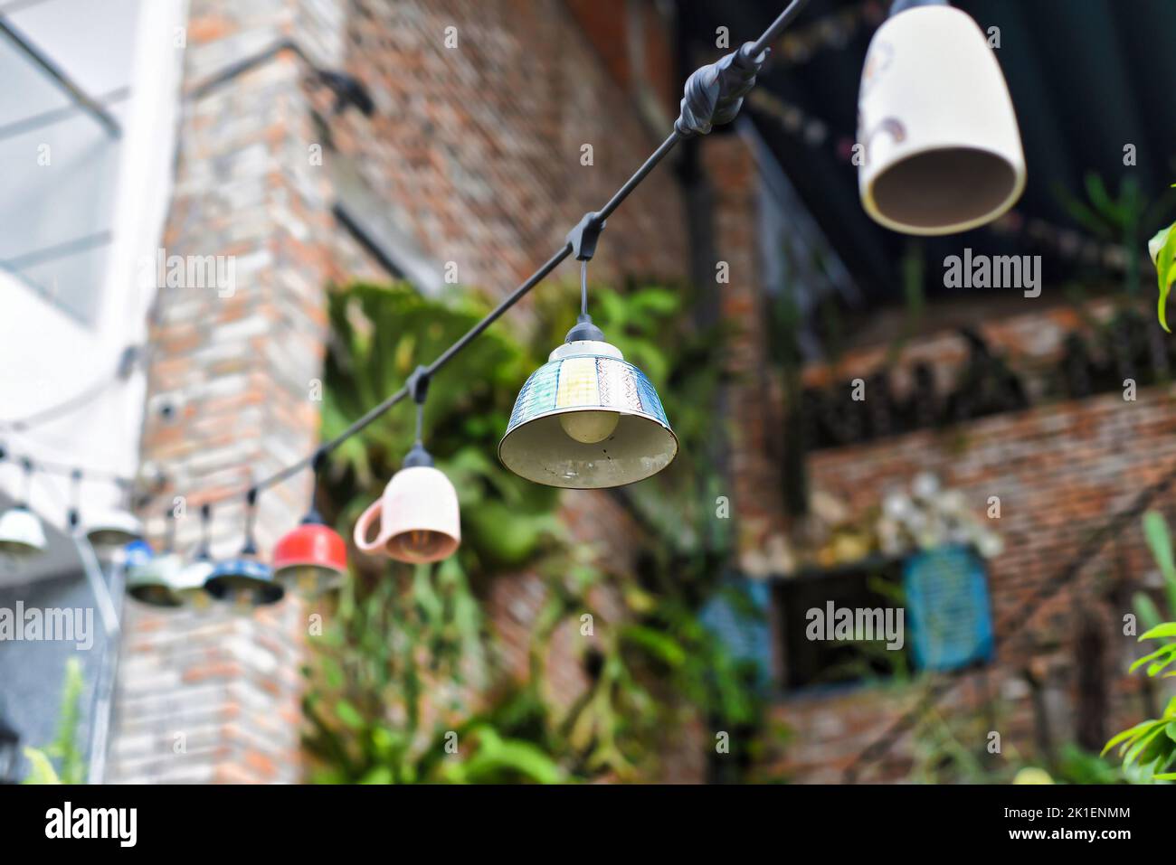 Creative design for garden: many old glass dishes with lights garland Stock Photo