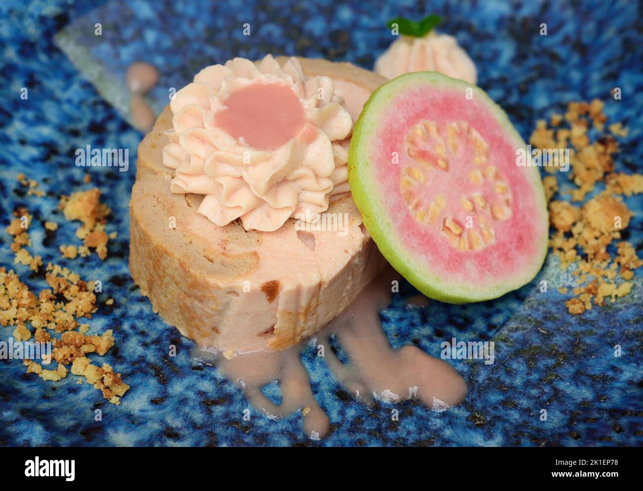 Guava Roll Cake on blue plate on light background with ripe guava fruit Stock Photo