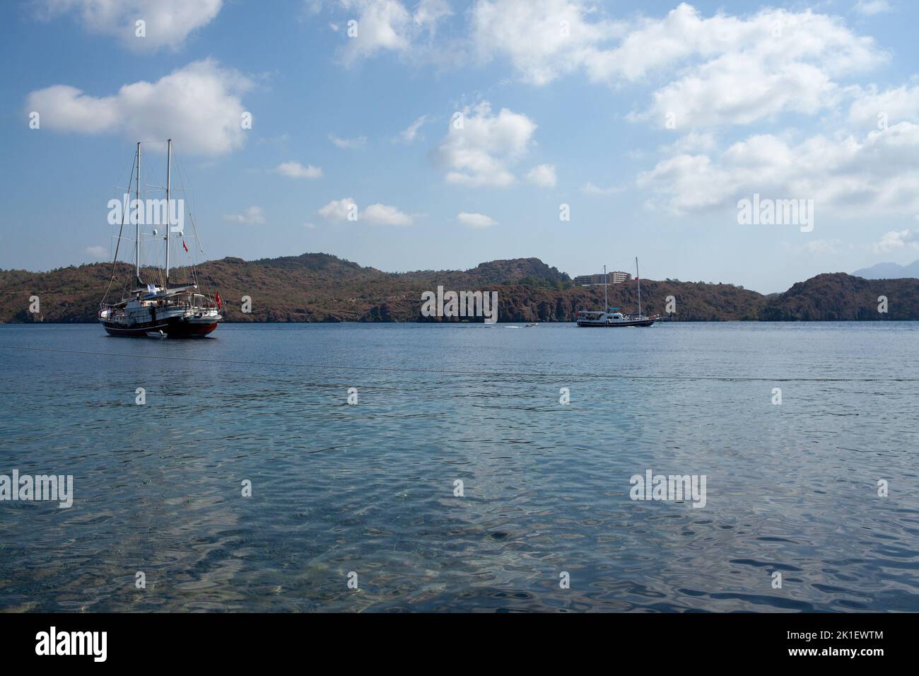 Pleasure yacht in the sea. Tourist ship with people on board with turkish flag sails on the waves. Fast moving excursion ship boat. Marmaris, Turkey - Stock Photo