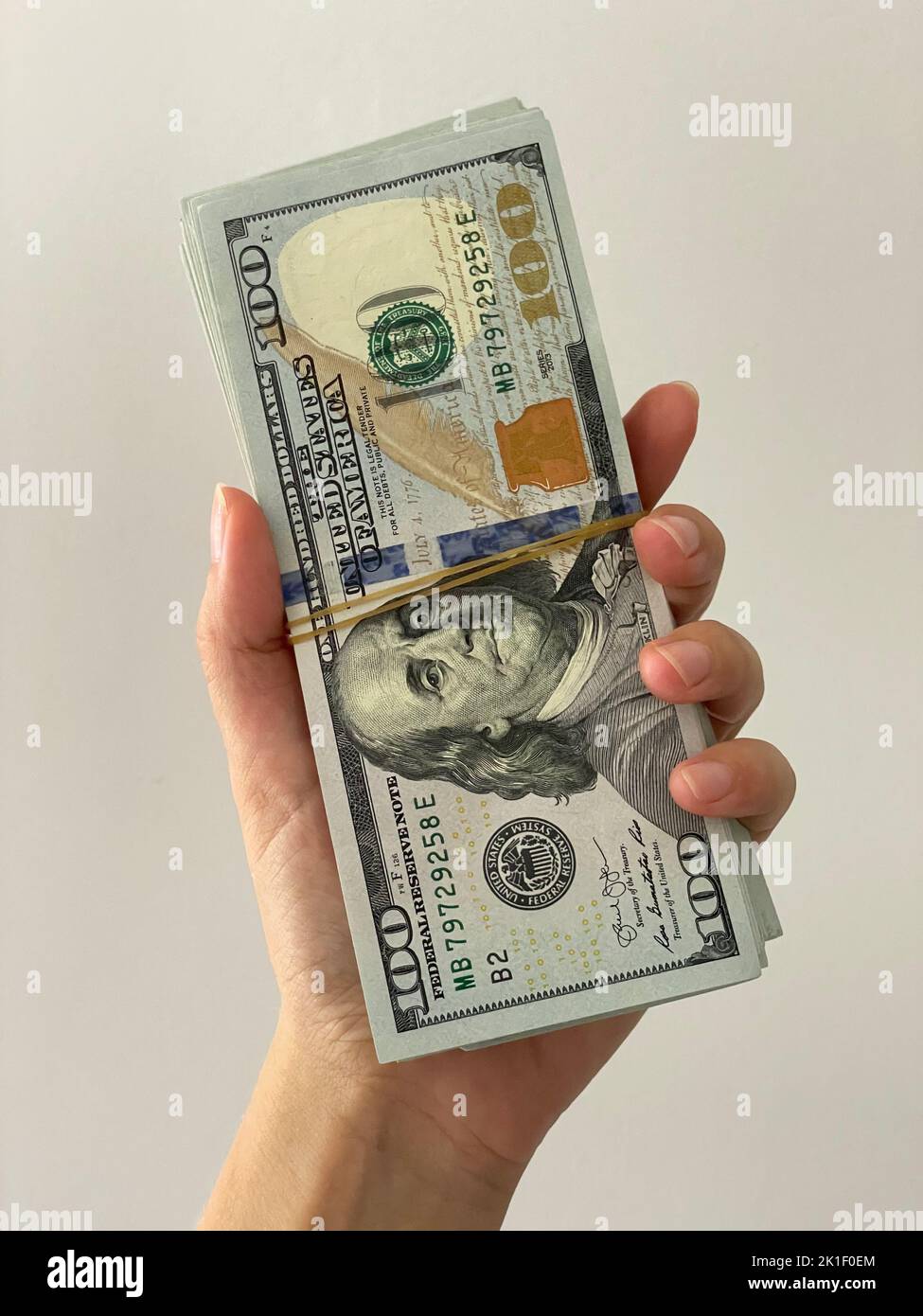 Woman holding a wad of money. Dollars in a hand Stock Photo