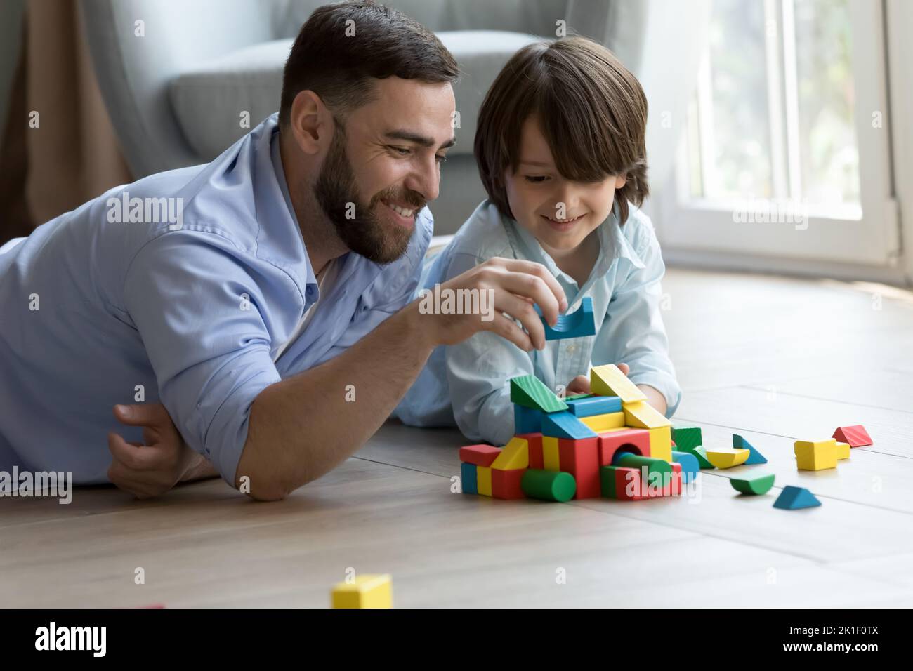 Happy dad teaching cute son kid to build toy forecast Stock Photo