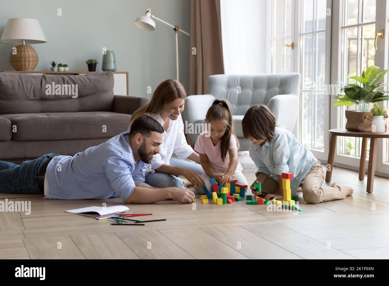 Happy parents and little son and daughter playing learning games Stock Photo