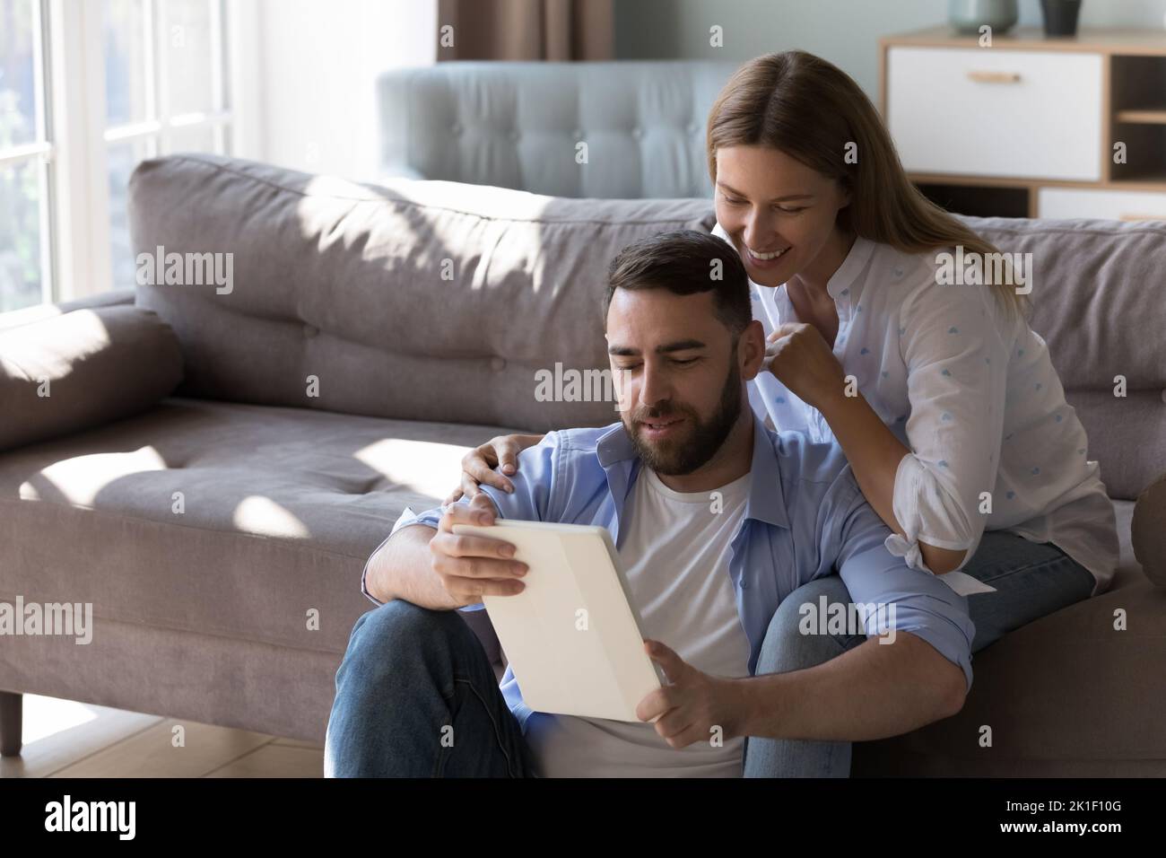 Happy 30s husband and wife using tablet computer Stock Photo