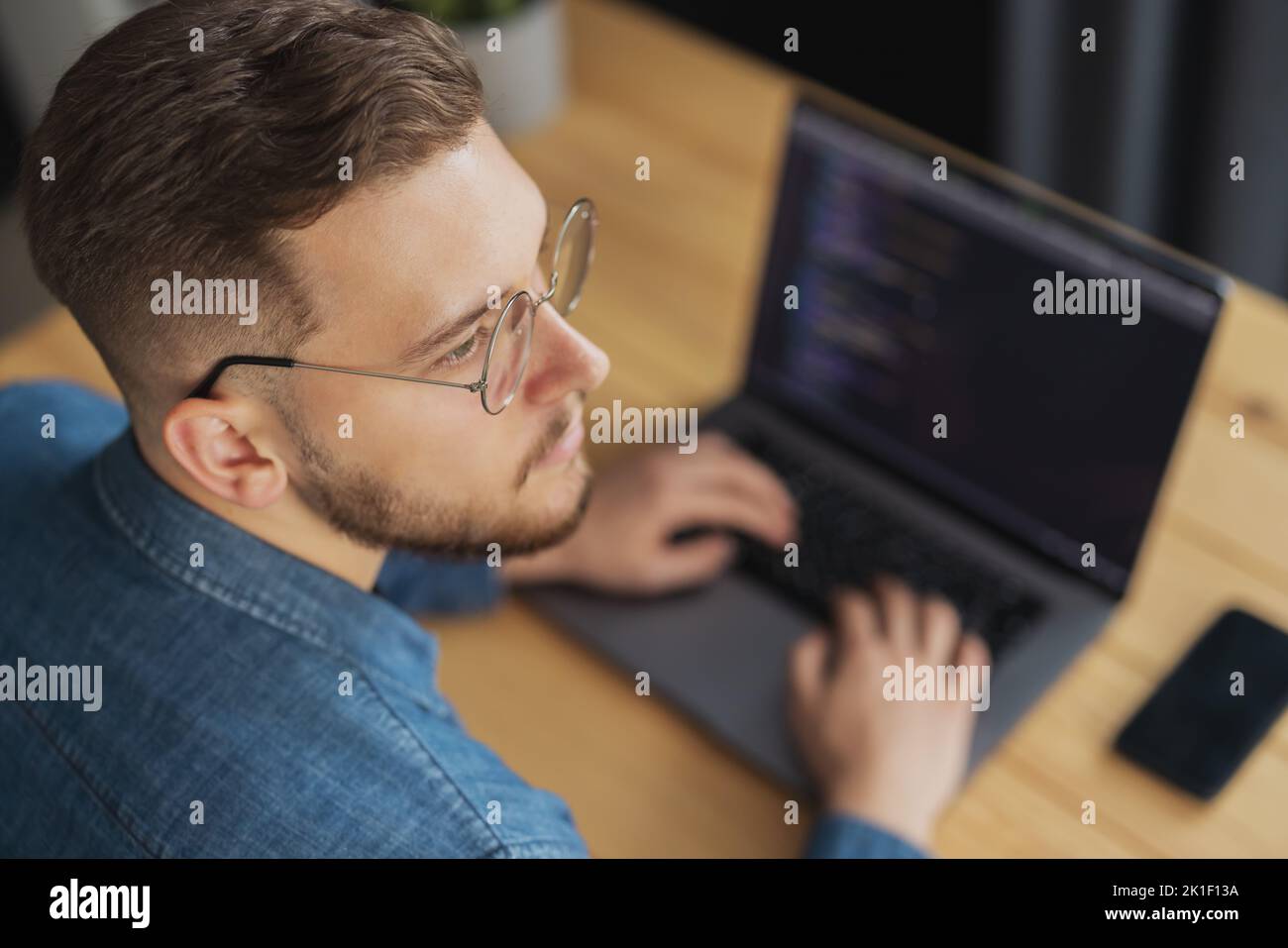 Man writing code on laptop Stock Photo
