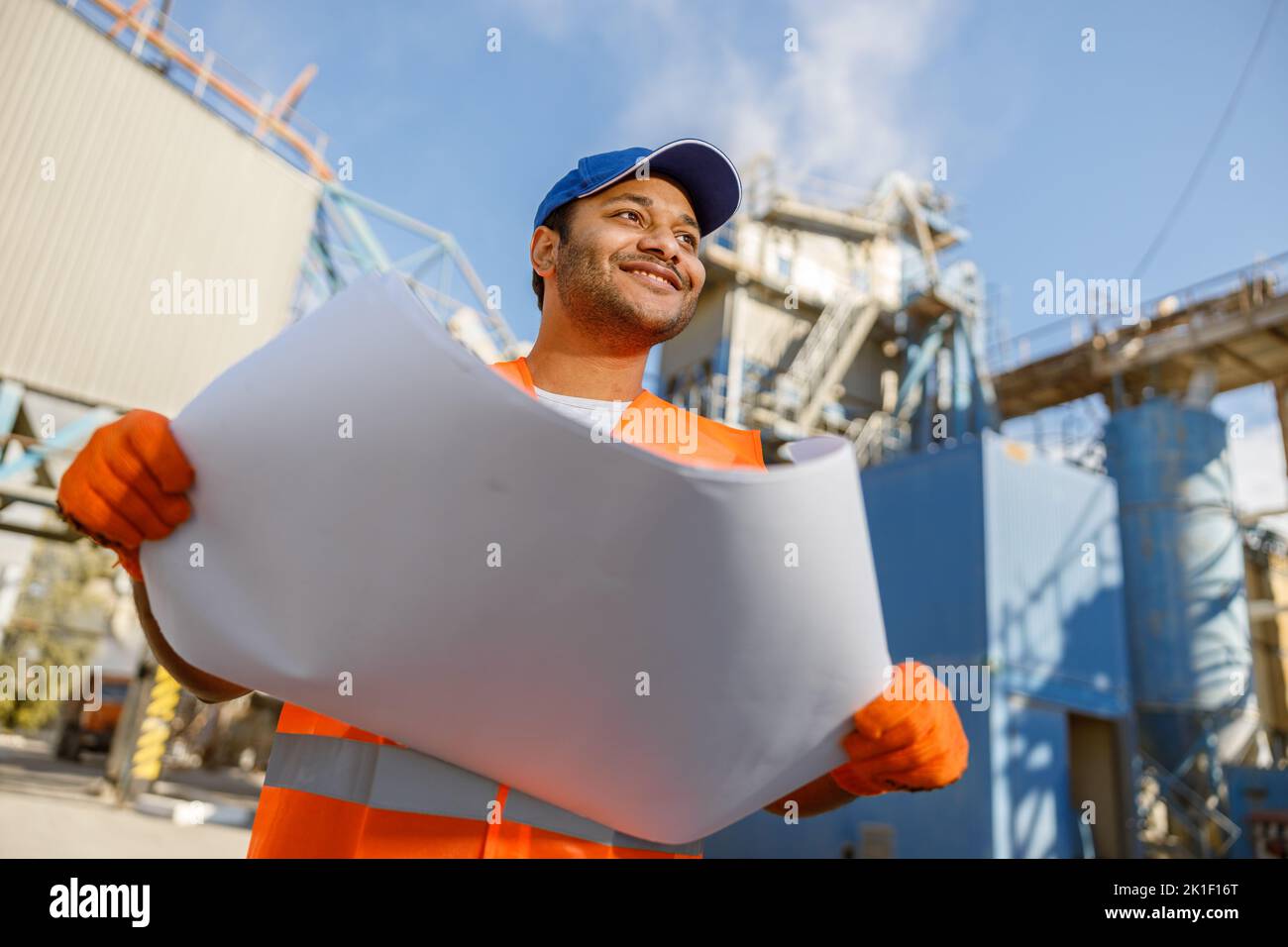 Smiling African engineer standing at industrial site Stock Photo