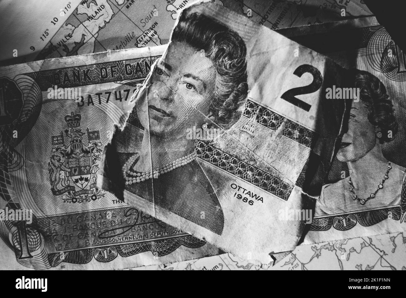 A grayscale closeup of torn Canadian two-dollar bill. Stock Photo