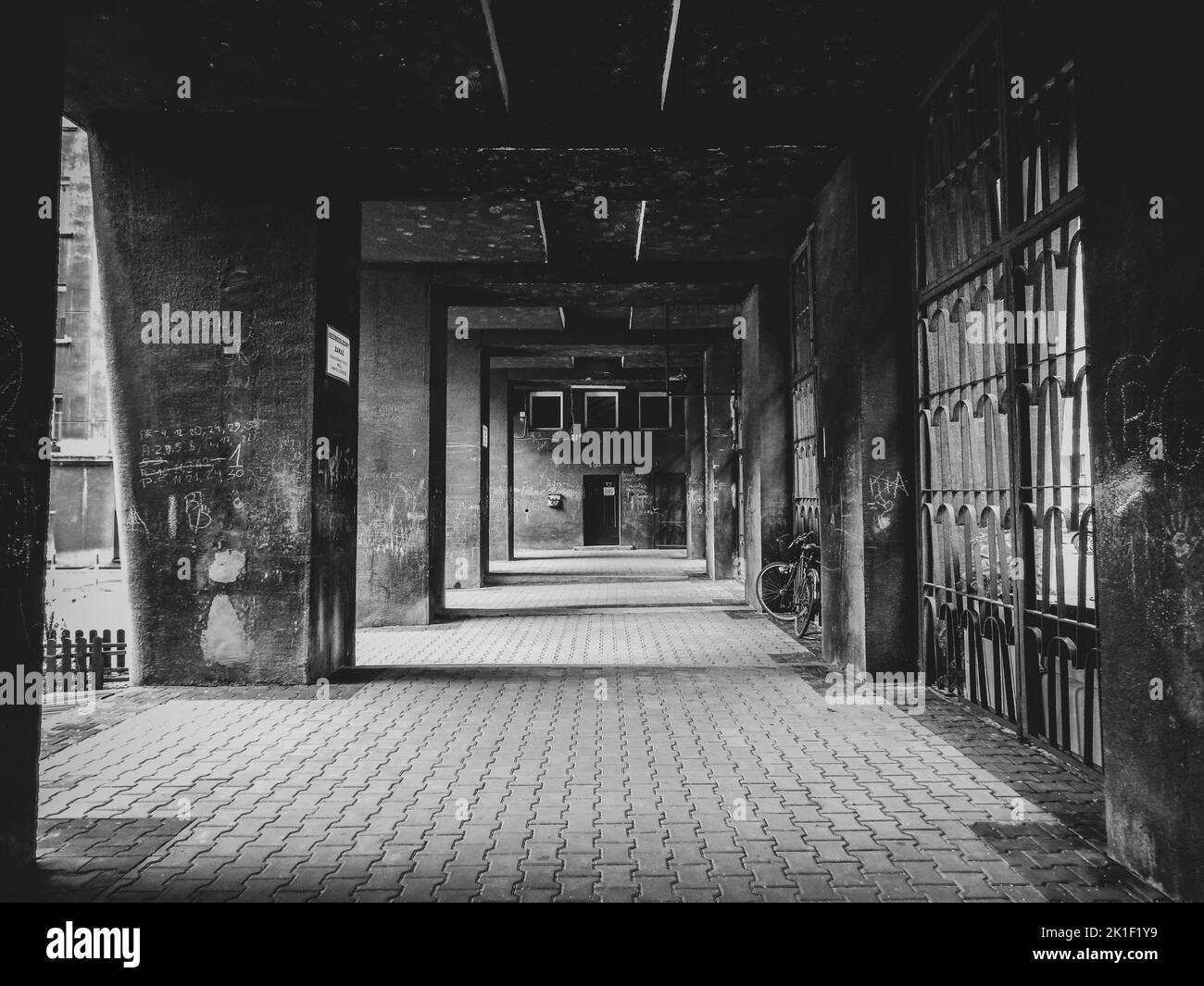 A covered pedestrian passage under a modern apartment building in black and white. Stock Photo