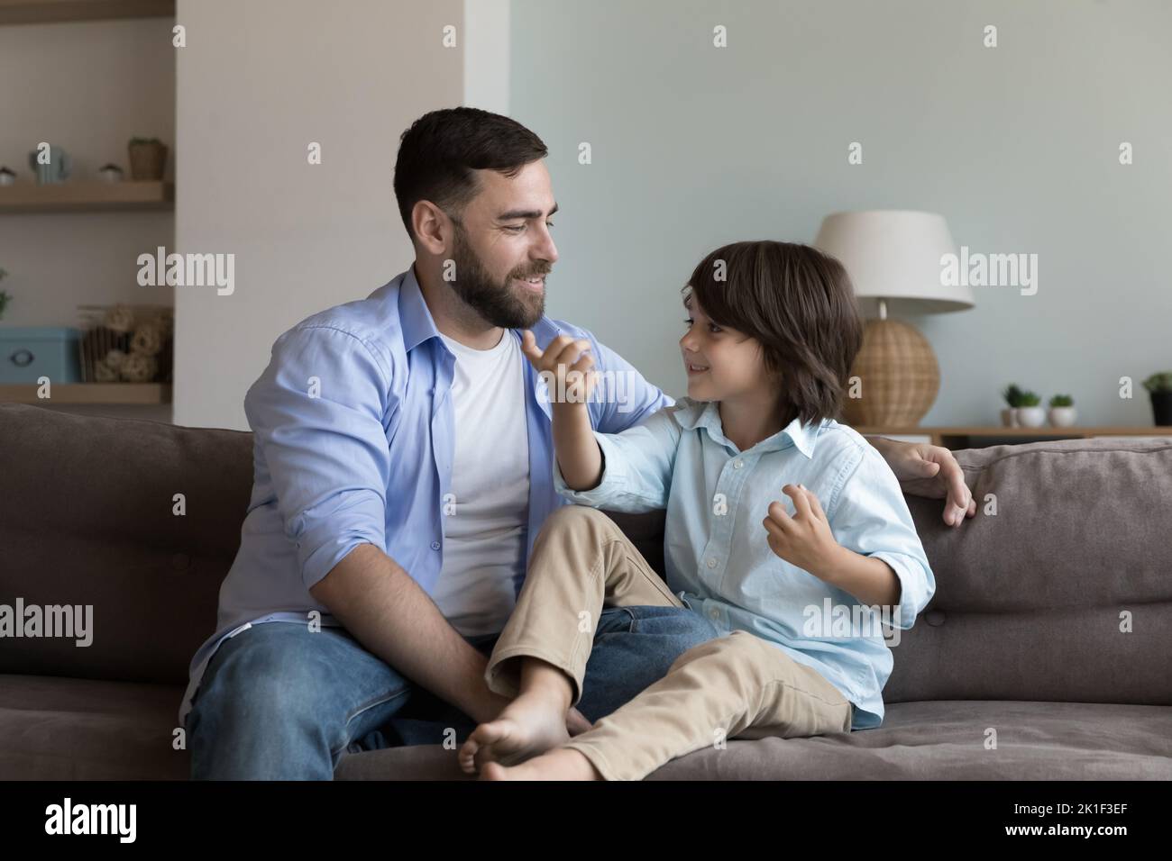Happy dad talking to little son kid, listening to child Stock Photo