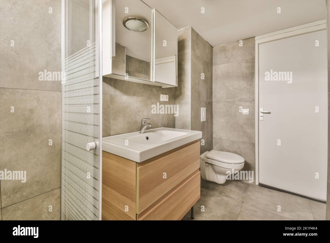 Glass partition between shower tap and wall hung toilet in modern