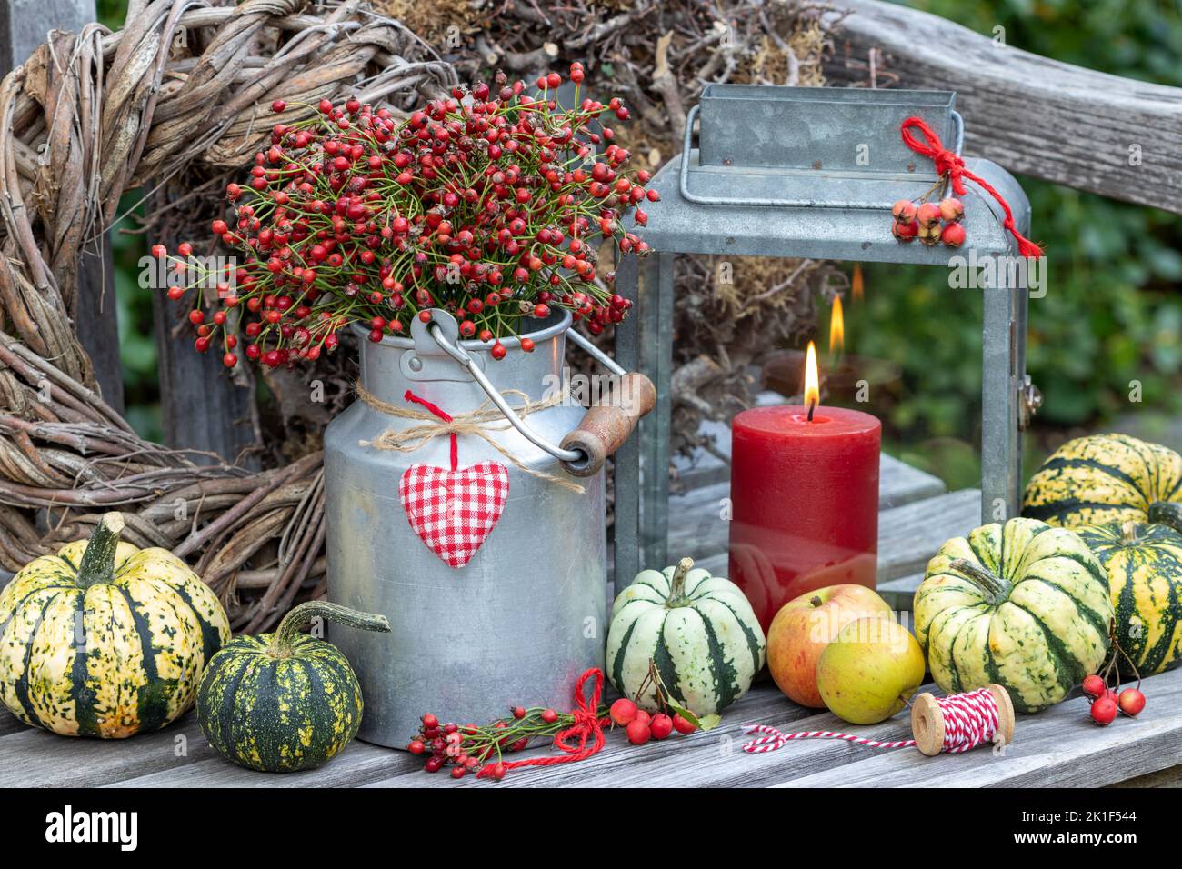 autumn arrangement with bouquet of rose hips, pumpkins and vintage lantern Stock Photo