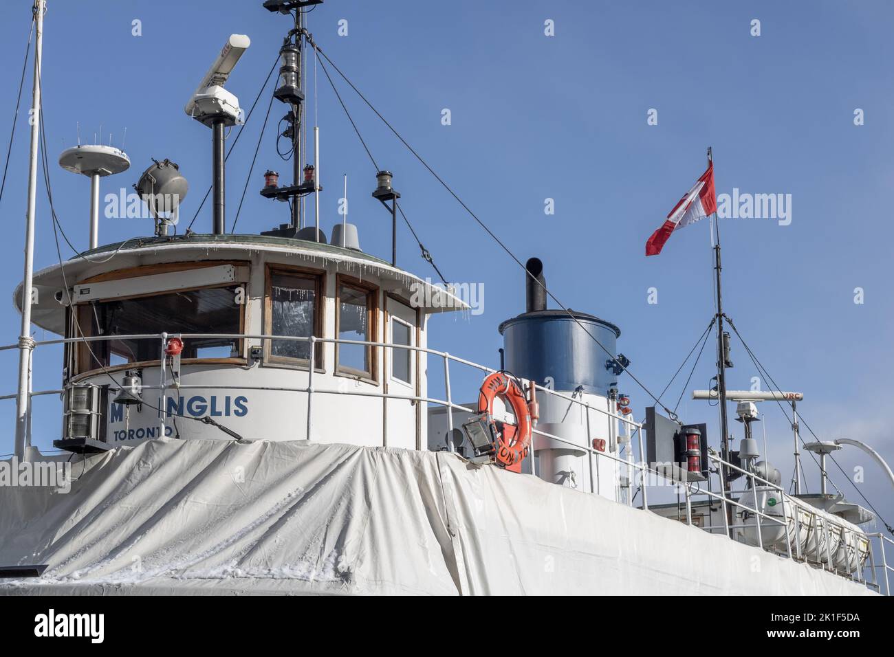 A ferry boat captured in Toronto, the wind moving the Canadian flag on the boat Stock Photo