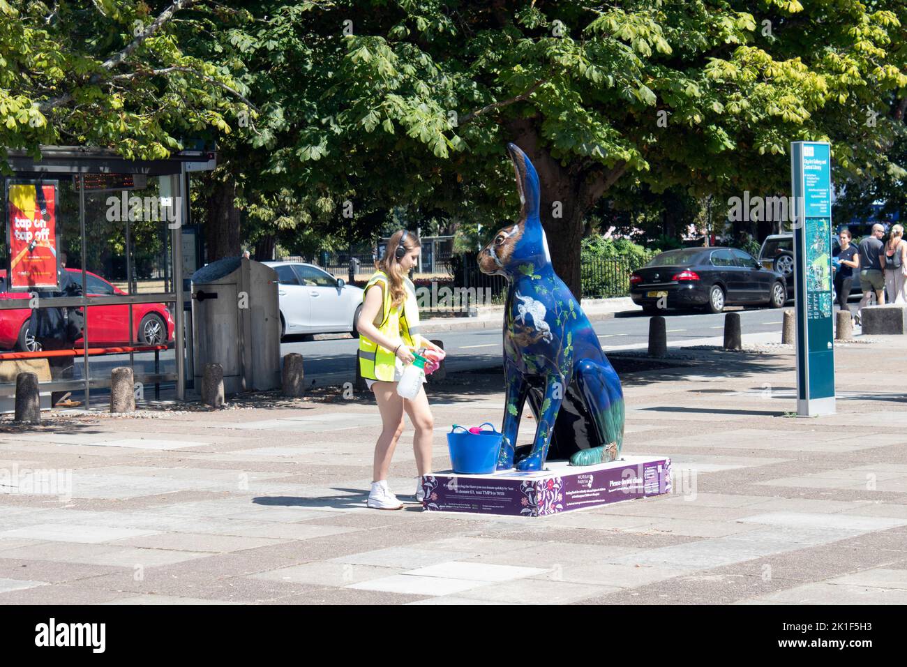 Woman cleaning a rabbit sculpture outside Southampton City Art Gallery Commercial Road Southampton England UK Stock Photo