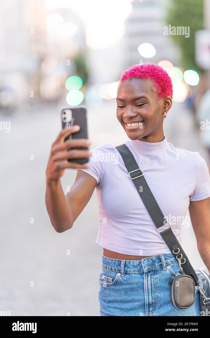 African woman with pink hair taking a selfie Stock Photo