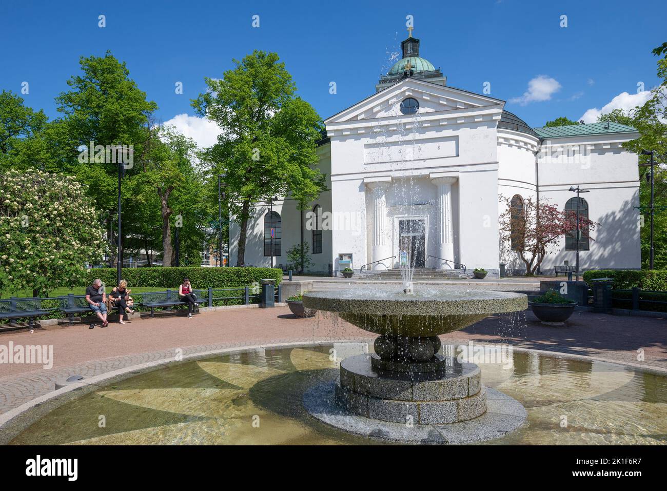 HAMEENLINNA, FINLAND - JUNE 10, 2017: City fountain against the background of an old Lutheran church on a sunny June day Stock Photo