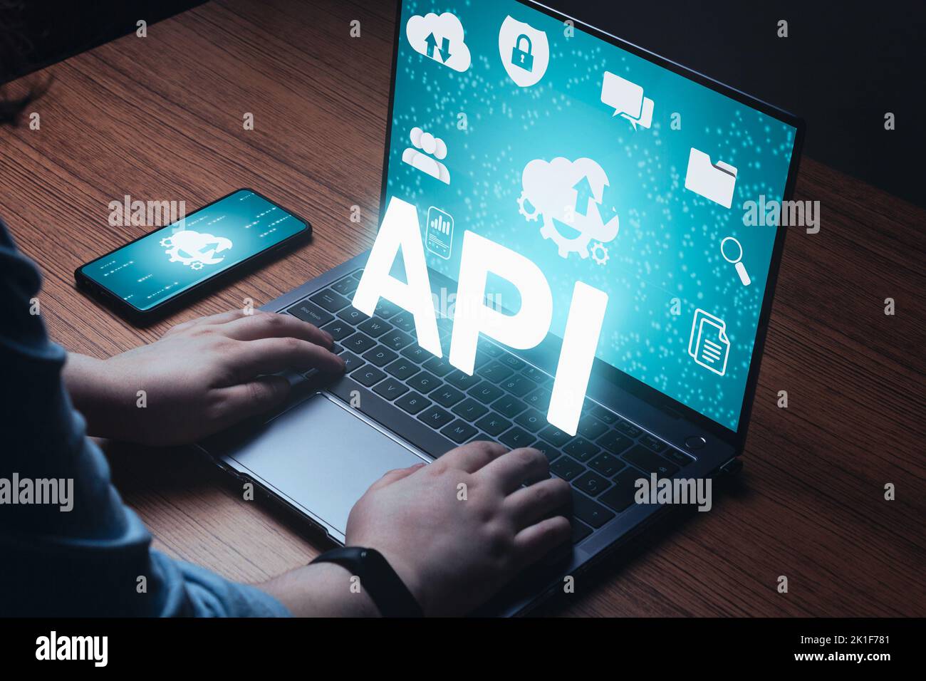 Woman use laptop with API word on VR screen and multimedia icons. Internet and technology concept. Business, programming, interface. Stock Photo