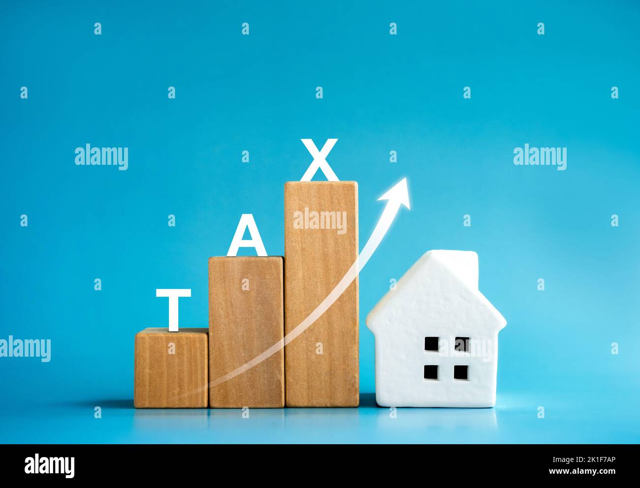 Home tax concept, residential or real estate property, land and building annual taxation. TAX, words on wooden cube blocks chart steps with rising arr Stock Photo