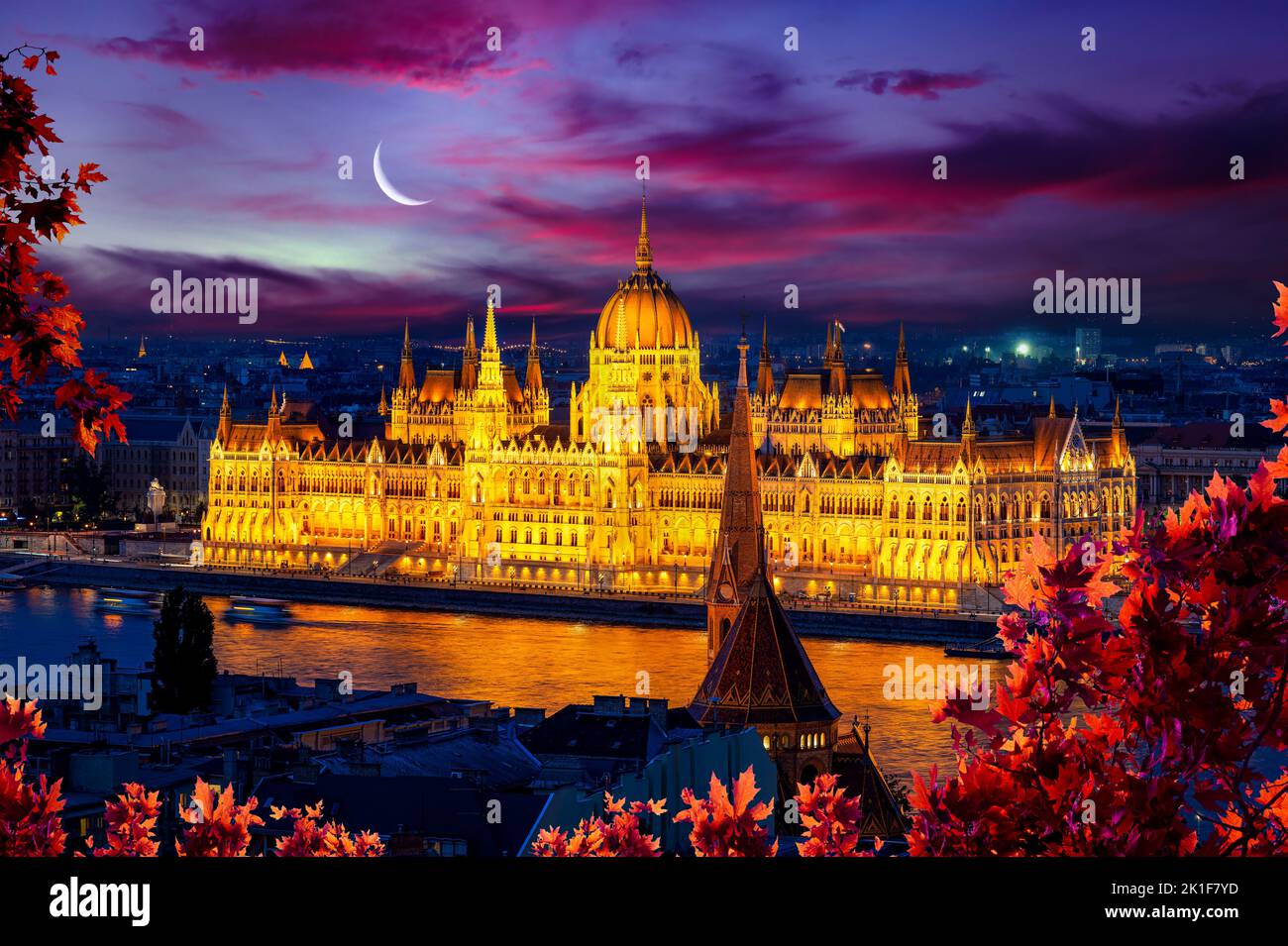 Facade of illuminated Budapest Parliament under cloudy sky, Hungary Stock Photo