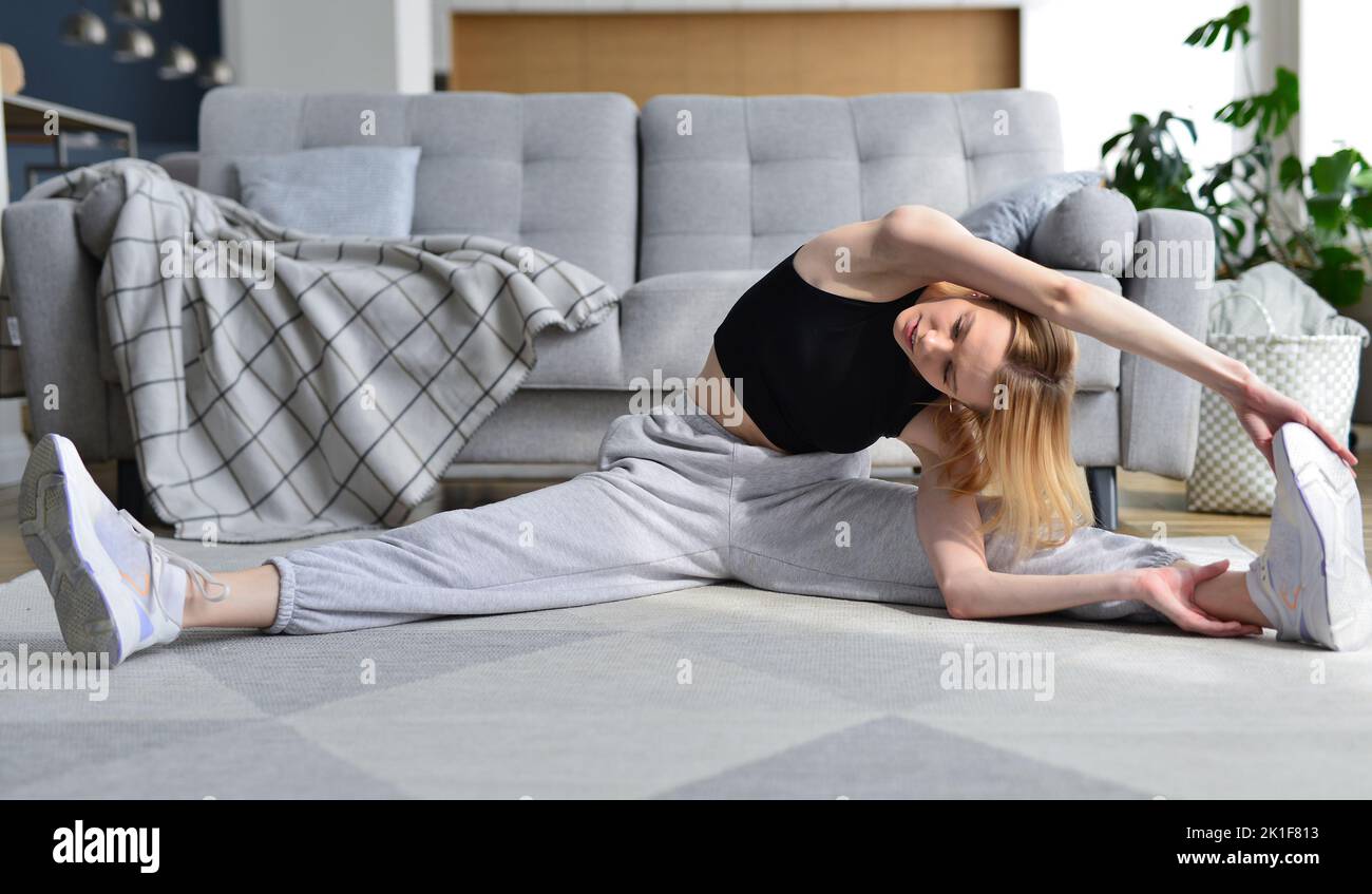 Woman doing stretching exercise at home Stock Photo