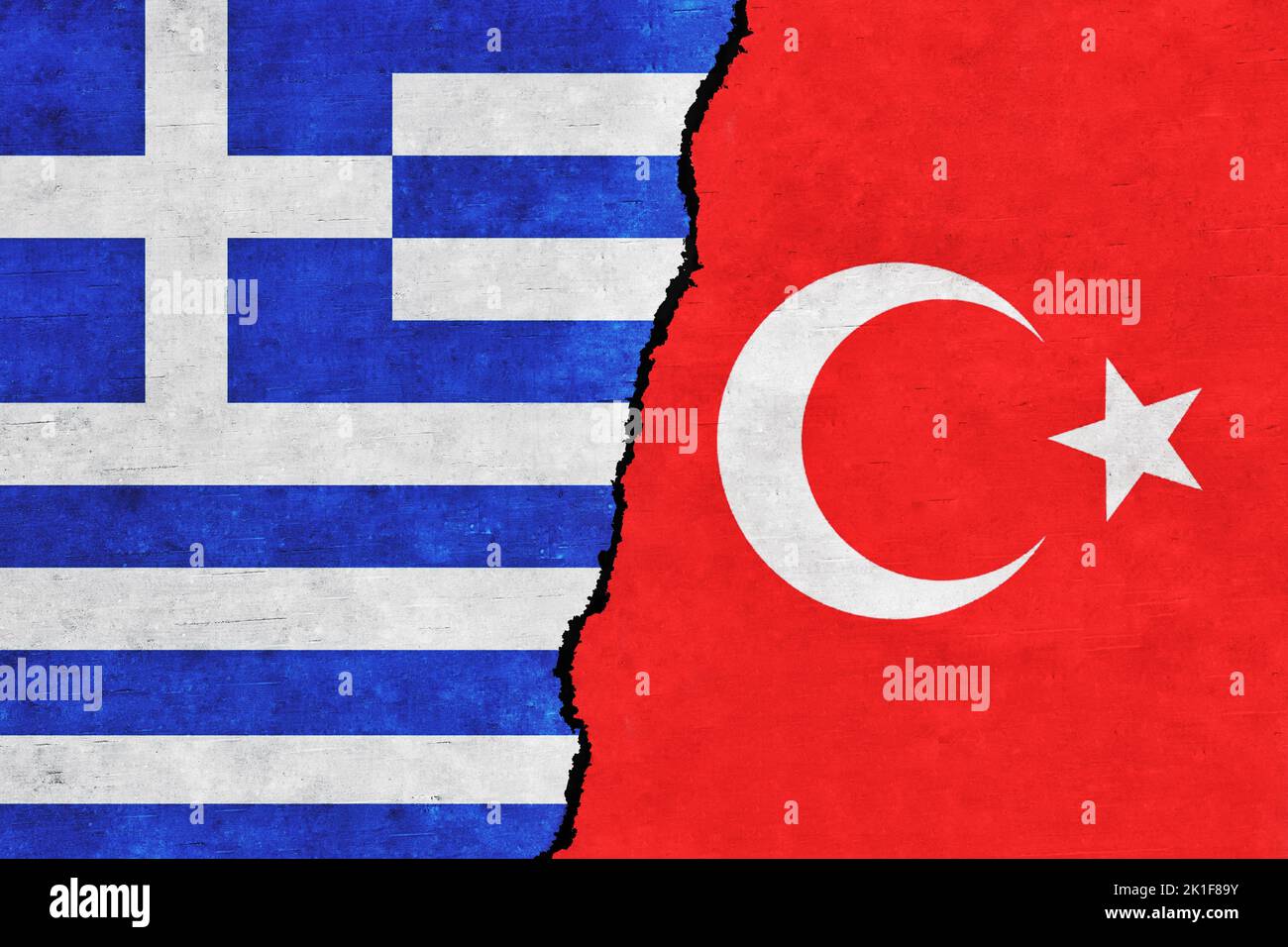 Turkey and Greece painted flags on a wall with a crack. Greece and