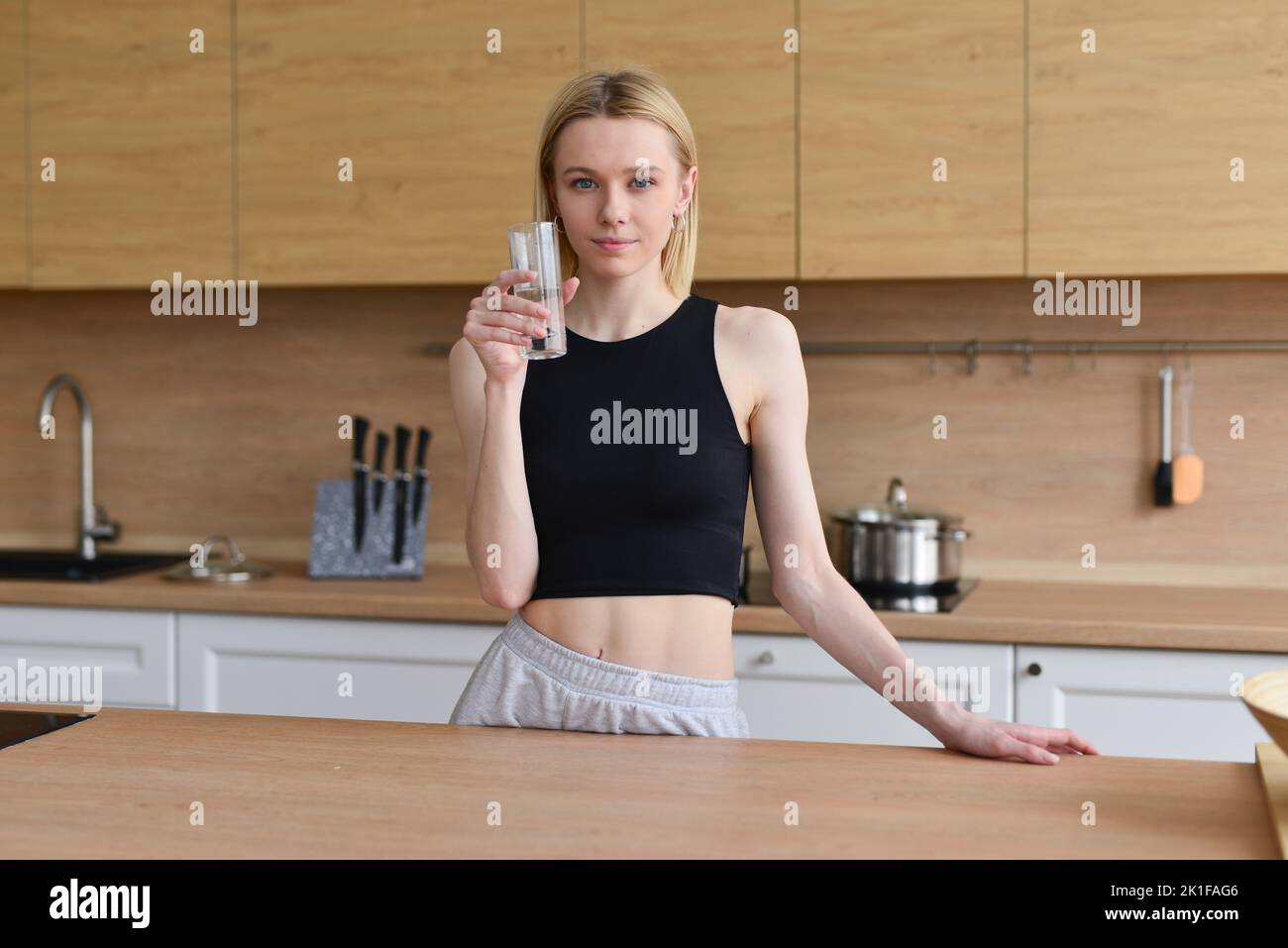 Woman drinking water in kitchen. Stock Photo